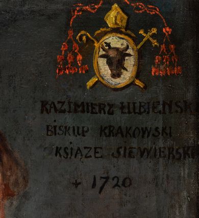 Zdjęcie nr 3: Biskup zwrócony trzy czwarte w lewo, ukazany w półpostaci. Twarz owalna, małe oczy, nos długi i wąskie usta, wyraźnie zaznaczony podbródek. Włosy brązowe, średniej długości. Biskup ubrany jest w rokietę, niebieski mantolet, białą befkę i niebieską piuskę. Na szyi ma zawieszony krzyż pektoralny. Tło jednolite i brązowe. W prawym, górnym narożu obrazu tarcza ujęta oznakami godności biskupiej (czerwonym kapeluszem z chwostami, infułą, pastorałem i krzyżem) z godłem herbu Pomian oraz poniżej napisem: „KAZIMIERZ ŁUBIEŃSKI / BISKUP KRAKOWSKI / KSIĄŻĘ SIEWIERSKI / + 1720”. 