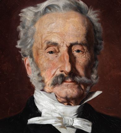 Zdjęcie nr 2: Obraz w kształcie stojącego owalu z przedstawieniem Pawła Popiela. Ujęcie portretowe, z torsem  zwróconym lekko w lewo i głową frontalnie. Popiel ma trójkątną twarz o małych oczach, garbatym nosie i wąskich ustach zakrytych częściowo. Zarost tworzą siwe wąsy i bokobrody, włosy ma zaczesane do tyłu. Jest ubrany w białą koszulę przewiązaną białą apaszką i czarną marynarkę. Przy dolnej krawędzi obrazu napis „*1807 PAWEŁ POPIEL +1892”. 