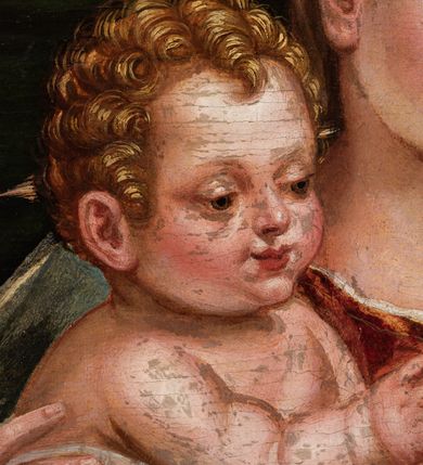 Zdjęcie nr 5: Obraz przedstawiający Matkę Boską z Dzieciątkiem stojącym na jej prawym udzie, siedzącą między stojącymi św. Barbarą z lewej strony i młodym św. Janem Chrzcicielem z prawej. Maria spogląda na jabłko podawane Jezusowi przez św. Jana. Ma okrągłą twarz, ciemne oczy , wąski nos i małe usta. Jest ubrana w czerwoną suknię i niebieski płaszcz ze złotym podbiciem. Jezus sięga w stronę jabłka, ma małą, okrągłą twarz i jasne włosy zwinięte w loki, jest przepasany białą tkaniną powyżej pasa. Święty Jan Chrzciciel został ukazany z profilu, jedną ręką podaje jabłko, w drugiej trzyma krzyż. Ma podłużną twarz z wysokim czołem, małym nosem i ciemnymi oczami, jest ubrany w skórę. Stojąca po drugiej stronie św. Barbara została ukazana lekko z tyłu, w rękach trzyma wieżę, twarz zwraca ku scenie, ma ciemne oczy, wśki nos i małe usta, włosy misternie zaplecione. Jest ubrana w ciemnozieloną suknię z czerwonymi rękawami i przezroczystym materiałem przy dekolcie. Biodra otacza żółty płaszcz. Tło sceny z lewej strony stanowi kotara, z prawej rozległy krajobraz.