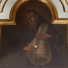 Zdjęcie nr 1: Obraz w kształcie leżącego prostokąta o wklęsłych bokach, zamknięty od góry łukiem nadwieszonym. W centrum kompozycji św. Kryspin z Viterbo ukazany do wysokości kolan, zwrócony delikatnie w swoją prawą stroną, z różańcem w prawej dłoni oraz torbą podróżną przerzuconą przez lewe ramię do przodu i przytrzymywaną obiema rękami. Święty ma podłużną twarz, z długim i wąskim nosem, wzrokiem skierowanym w dół, okoloną długą i siwą brodą oraz krótkimi włosami z zakolami. Ubrany jest w habit franciszkański. Torba szaro-biała, tło obrazu jednolite, w odcieniach ugru i brązu.