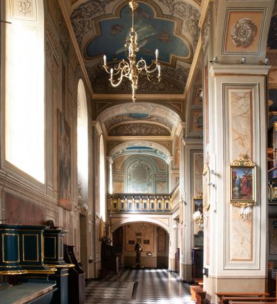 Zdjęcie nr 83: Kościół orientowany, murowany, trzynawowy. Typ halowy, z węższym, prostokątnym prezbiterium zamkniętym trójbocznie oraz z wieżą wbudowaną w zachodnią fasadę. Do prezbiterium od północy przylega zakrystia (do niej od zachodu klatka schodowa wiodąca do skarbca na piętrze), od południa natomiast kaplica Morsztynów z XVII wieku. Kaplica na planie prostokąta zamkniętego trójbocznie, z niszami w ściętych narożach, pod nią sklepiona krypta grobowa, opięta pilastrami wewnątrz i na zewnątrz. Od południa do korpusu przylega kruchta stanowiąca również kaplicę Matki Boskiej Pocieszenia. Korpus czteroprzęsłowy, nawy oddzielają arkady wsparte na filarach, pierwsze stanowią podparcie dla chóru. Nad nawami i prezbiterium strop imitujący sklepienie, na którym malowana dekoracja imitująca gurty, plafony oraz stiuki. Dekoracja ścian powtarza podziały wyznaczone przez arkady, namalowano na nich pilastry podtrzymujące belkowanie. W prezbiterium dwa okna usytuowane niedaleko ołtarza, w nawie osiem, wszystkie w kształcie stojącego prostokąta zamkniętego półkoliście, wypełnione witrażami z dekoracją geometryczną. Główne wejście od zachodu, drugie od północy, trzecie symetrycznie od południa przez kruchtę sklepioną kopułą, kolejne trzy do prezbiterium, od południa przez zakrystię i od północy przez kruchtę. 
Fasada zachodnia na cokole, podzielona gzymsami i lizenami, z wieżą zakończoną hełmem. Na osi drzwi w kształcie stojącego prostokąta flankowane prostokątnymi oknami, powyżej trzecie, większe okno zamknięte łukiem odcinkowym; kondygnację wieńczy gzyms. Druga kondygnacja powtarza podziały pierwszej. W środkowej osi okulus, powyżej dwudzielne okno zamknięte półkoliście. Nad nim tarcza zegara, kolejne dwie na ścianach bocznych. Kondygnacja ograniczona po bokach spływali wolutowymi i obeliskami zakończonymi kulami; przechodzi w wieżę. Powyżej gzyms podtrzymywany kroksztynami. Ostatnia kondygnacja o artykulacji ramowej z balkonami z każdej strony, powyżej wieńczącego gzymsu. Pozostałe elewacje na cokole, kontynuują podziały  lizenowo-ramowe, artykulacją podkreślają okna. Kaplica Morsztynów opięta pilastrami z głowicami, prezbiterium oszkarpowane. Dach nad nawą główną, kaplicą i prezbiterium dwuspadowy, na kruchtą południową kopuła, na wieży ozdobny hełm dołem wklęsły, dekorowany wolutami. Powyżej kopuła, na której latarnia przepruta arkadami i zwieńczona przewężoną w środku kopułą zakończoną ostrosłupem z kulą i krzyżem. 
Do najcenniejszych zabytków świątyni należą m.in. zaprojektowana przez Jana Delamarsa kaplica Morsztynów dekorowana stiukami z 1693 roku autorstwa Baltazara Fontany. Wewnątrz niej warto zwrócić uwagę na osiemnastowieczny ołtarz z przedstawieniem Oblicza Chrystusa i rzeźbionym antepedium. W ołtarz Ukrzyżowania znajdujący się w północnej nawie kościoła wkomponowano gotyckie rzeźby św. Jana i Marii. 