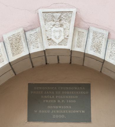 Zdjęcie nr 60: Kościół orientowany, murowany, trzynawowy. Typ halowy, z węższym, prostokątnym prezbiterium zamkniętym trójbocznie oraz z wieżą wbudowaną w zachodnią fasadę. Do prezbiterium od północy przylega zakrystia (do niej od zachodu klatka schodowa wiodąca do skarbca na piętrze), od południa natomiast kaplica Morsztynów z XVII wieku. Kaplica na planie prostokąta zamkniętego trójbocznie, z niszami w ściętych narożach, pod nią sklepiona krypta grobowa, opięta pilastrami wewnątrz i na zewnątrz. Od południa do korpusu przylega kruchta stanowiąca również kaplicę Matki Boskiej Pocieszenia. Korpus czteroprzęsłowy, nawy oddzielają arkady wsparte na filarach, pierwsze stanowią podparcie dla chóru. Nad nawami i prezbiterium strop imitujący sklepienie, na którym malowana dekoracja imitująca gurty, plafony oraz stiuki. Dekoracja ścian powtarza podziały wyznaczone przez arkady, namalowano na nich pilastry podtrzymujące belkowanie. W prezbiterium dwa okna usytuowane niedaleko ołtarza, w nawie osiem, wszystkie w kształcie stojącego prostokąta zamkniętego półkoliście, wypełnione witrażami z dekoracją geometryczną. Główne wejście od zachodu, drugie od północy, trzecie symetrycznie od południa przez kruchtę sklepioną kopułą, kolejne trzy do prezbiterium, od południa przez zakrystię i od północy przez kruchtę. 
Fasada zachodnia na cokole, podzielona gzymsami i lizenami, z wieżą zakończoną hełmem. Na osi drzwi w kształcie stojącego prostokąta flankowane prostokątnymi oknami, powyżej trzecie, większe okno zamknięte łukiem odcinkowym; kondygnację wieńczy gzyms. Druga kondygnacja powtarza podziały pierwszej. W środkowej osi okulus, powyżej dwudzielne okno zamknięte półkoliście. Nad nim tarcza zegara, kolejne dwie na ścianach bocznych. Kondygnacja ograniczona po bokach spływali wolutowymi i obeliskami zakończonymi kulami; przechodzi w wieżę. Powyżej gzyms podtrzymywany kroksztynami. Ostatnia kondygnacja o artykulacji ramowej z balkonami z każdej strony, powyżej wieńczącego gzymsu. Pozostałe elewacje na cokole, kontynuują podziały  lizenowo-ramowe, artykulacją podkreślają okna. Kaplica Morsztynów opięta pilastrami z głowicami, prezbiterium oszkarpowane. Dach nad nawą główną, kaplicą i prezbiterium dwuspadowy, na kruchtą południową kopuła, na wieży ozdobny hełm dołem wklęsły, dekorowany wolutami. Powyżej kopuła, na której latarnia przepruta arkadami i zwieńczona przewężoną w środku kopułą zakończoną ostrosłupem z kulą i krzyżem. 
Do najcenniejszych zabytków świątyni należą m.in. zaprojektowana przez Jana Delamarsa kaplica Morsztynów dekorowana stiukami z 1693 roku autorstwa Baltazara Fontany. Wewnątrz niej warto zwrócić uwagę na osiemnastowieczny ołtarz z przedstawieniem Oblicza Chrystusa i rzeźbionym antepedium. W ołtarz Ukrzyżowania znajdujący się w północnej nawie kościoła wkomponowano gotyckie rzeźby św. Jana i Marii. 