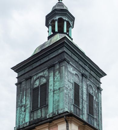 Zdjęcie nr 38: Kościół orientowany, murowany, trzynawowy. Typ halowy, z węższym, prostokątnym prezbiterium zamkniętym trójbocznie oraz z wieżą wbudowaną w zachodnią fasadę. Do prezbiterium od północy przylega zakrystia (do niej od zachodu klatka schodowa wiodąca do skarbca na piętrze), od południa natomiast kaplica Morsztynów z XVII wieku. Kaplica na planie prostokąta zamkniętego trójbocznie, z niszami w ściętych narożach, pod nią sklepiona krypta grobowa, opięta pilastrami wewnątrz i na zewnątrz. Od południa do korpusu przylega kruchta stanowiąca również kaplicę Matki Boskiej Pocieszenia. Korpus czteroprzęsłowy, nawy oddzielają arkady wsparte na filarach, pierwsze stanowią podparcie dla chóru. Nad nawami i prezbiterium strop imitujący sklepienie, na którym malowana dekoracja imitująca gurty, plafony oraz stiuki. Dekoracja ścian powtarza podziały wyznaczone przez arkady, namalowano na nich pilastry podtrzymujące belkowanie. W prezbiterium dwa okna usytuowane niedaleko ołtarza, w nawie osiem, wszystkie w kształcie stojącego prostokąta zamkniętego półkoliście, wypełnione witrażami z dekoracją geometryczną. Główne wejście od zachodu, drugie od północy, trzecie symetrycznie od południa przez kruchtę sklepioną kopułą, kolejne trzy do prezbiterium, od południa przez zakrystię i od północy przez kruchtę. 
Fasada zachodnia na cokole, podzielona gzymsami i lizenami, z wieżą zakończoną hełmem. Na osi drzwi w kształcie stojącego prostokąta flankowane prostokątnymi oknami, powyżej trzecie, większe okno zamknięte łukiem odcinkowym; kondygnację wieńczy gzyms. Druga kondygnacja powtarza podziały pierwszej. W środkowej osi okulus, powyżej dwudzielne okno zamknięte półkoliście. Nad nim tarcza zegara, kolejne dwie na ścianach bocznych. Kondygnacja ograniczona po bokach spływali wolutowymi i obeliskami zakończonymi kulami; przechodzi w wieżę. Powyżej gzyms podtrzymywany kroksztynami. Ostatnia kondygnacja o artykulacji ramowej z balkonami z każdej strony, powyżej wieńczącego gzymsu. Pozostałe elewacje na cokole, kontynuują podziały  lizenowo-ramowe, artykulacją podkreślają okna. Kaplica Morsztynów opięta pilastrami z głowicami, prezbiterium oszkarpowane. Dach nad nawą główną, kaplicą i prezbiterium dwuspadowy, na kruchtą południową kopuła, na wieży ozdobny hełm dołem wklęsły, dekorowany wolutami. Powyżej kopuła, na której latarnia przepruta arkadami i zwieńczona przewężoną w środku kopułą zakończoną ostrosłupem z kulą i krzyżem. 
Do najcenniejszych zabytków świątyni należą m.in. zaprojektowana przez Jana Delamarsa kaplica Morsztynów dekorowana stiukami z 1693 roku autorstwa Baltazara Fontany. Wewnątrz niej warto zwrócić uwagę na osiemnastowieczny ołtarz z przedstawieniem Oblicza Chrystusa i rzeźbionym antepedium. W ołtarz Ukrzyżowania znajdujący się w północnej nawie kościoła wkomponowano gotyckie rzeźby św. Jana i Marii. 