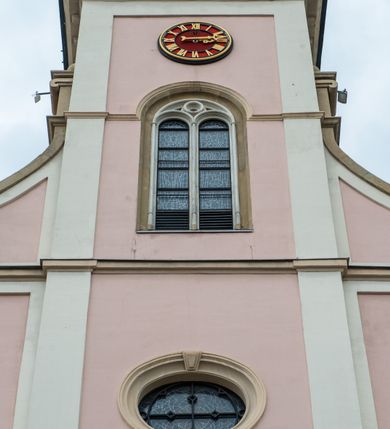 Zdjęcie nr 10: Kościół orientowany, murowany, trzynawowy. Typ halowy, z węższym, prostokątnym prezbiterium zamkniętym trójbocznie oraz z wieżą wbudowaną w zachodnią fasadę. Do prezbiterium od północy przylega zakrystia (do niej od zachodu klatka schodowa wiodąca do skarbca na piętrze), od południa natomiast kaplica Morsztynów z XVII wieku. Kaplica na planie prostokąta zamkniętego trójbocznie, z niszami w ściętych narożach, pod nią sklepiona krypta grobowa, opięta pilastrami wewnątrz i na zewnątrz. Od południa do korpusu przylega kruchta stanowiąca również kaplicę Matki Boskiej Pocieszenia. Korpus czteroprzęsłowy, nawy oddzielają arkady wsparte na filarach, pierwsze stanowią podparcie dla chóru. Nad nawami i prezbiterium strop imitujący sklepienie, na którym malowana dekoracja imitująca gurty, plafony oraz stiuki. Dekoracja ścian powtarza podziały wyznaczone przez arkady, namalowano na nich pilastry podtrzymujące belkowanie. W prezbiterium dwa okna usytuowane niedaleko ołtarza, w nawie osiem, wszystkie w kształcie stojącego prostokąta zamkniętego półkoliście, wypełnione witrażami z dekoracją geometryczną. Główne wejście od zachodu, drugie od północy, trzecie symetrycznie od południa przez kruchtę sklepioną kopułą, kolejne trzy do prezbiterium, od południa przez zakrystię i od północy przez kruchtę. 
Fasada zachodnia na cokole, podzielona gzymsami i lizenami, z wieżą zakończoną hełmem. Na osi drzwi w kształcie stojącego prostokąta flankowane prostokątnymi oknami, powyżej trzecie, większe okno zamknięte łukiem odcinkowym; kondygnację wieńczy gzyms. Druga kondygnacja powtarza podziały pierwszej. W środkowej osi okulus, powyżej dwudzielne okno zamknięte półkoliście. Nad nim tarcza zegara, kolejne dwie na ścianach bocznych. Kondygnacja ograniczona po bokach spływali wolutowymi i obeliskami zakończonymi kulami; przechodzi w wieżę. Powyżej gzyms podtrzymywany kroksztynami. Ostatnia kondygnacja o artykulacji ramowej z balkonami z każdej strony, powyżej wieńczącego gzymsu. Pozostałe elewacje na cokole, kontynuują podziały  lizenowo-ramowe, artykulacją podkreślają okna. Kaplica Morsztynów opięta pilastrami z głowicami, prezbiterium oszkarpowane. Dach nad nawą główną, kaplicą i prezbiterium dwuspadowy, na kruchtą południową kopuła, na wieży ozdobny hełm dołem wklęsły, dekorowany wolutami. Powyżej kopuła, na której latarnia przepruta arkadami i zwieńczona przewężoną w środku kopułą zakończoną ostrosłupem z kulą i krzyżem. 
Do najcenniejszych zabytków świątyni należą m.in. zaprojektowana przez Jana Delamarsa kaplica Morsztynów dekorowana stiukami z 1693 roku autorstwa Baltazara Fontany. Wewnątrz niej warto zwrócić uwagę na osiemnastowieczny ołtarz z przedstawieniem Oblicza Chrystusa i rzeźbionym antepedium. W ołtarz Ukrzyżowania znajdujący się w północnej nawie kościoła wkomponowano gotyckie rzeźby św. Jana i Marii. 