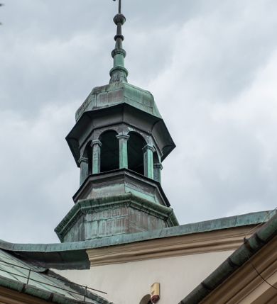 Zdjęcie nr 13: Kościół orientowany, murowany, trzynawowy. Typ halowy, z węższym, prostokątnym prezbiterium zamkniętym trójbocznie oraz z wieżą wbudowaną w zachodnią fasadę. Do prezbiterium od północy przylega zakrystia (do niej od zachodu klatka schodowa wiodąca do skarbca na piętrze), od południa natomiast kaplica Morsztynów z XVII wieku. Kaplica na planie prostokąta zamkniętego trójbocznie, z niszami w ściętych narożach, pod nią sklepiona krypta grobowa, opięta pilastrami wewnątrz i na zewnątrz. Od południa do korpusu przylega kruchta stanowiąca również kaplicę Matki Boskiej Pocieszenia. Korpus czteroprzęsłowy, nawy oddzielają arkady wsparte na filarach, pierwsze stanowią podparcie dla chóru. Nad nawami i prezbiterium strop imitujący sklepienie, na którym malowana dekoracja imitująca gurty, plafony oraz stiuki. Dekoracja ścian powtarza podziały wyznaczone przez arkady, namalowano na nich pilastry podtrzymujące belkowanie. W prezbiterium dwa okna usytuowane niedaleko ołtarza, w nawie osiem, wszystkie w kształcie stojącego prostokąta zamkniętego półkoliście, wypełnione witrażami z dekoracją geometryczną. Główne wejście od zachodu, drugie od północy, trzecie symetrycznie od południa przez kruchtę sklepioną kopułą, kolejne trzy do prezbiterium, od południa przez zakrystię i od północy przez kruchtę. 
Fasada zachodnia na cokole, podzielona gzymsami i lizenami, z wieżą zakończoną hełmem. Na osi drzwi w kształcie stojącego prostokąta flankowane prostokątnymi oknami, powyżej trzecie, większe okno zamknięte łukiem odcinkowym; kondygnację wieńczy gzyms. Druga kondygnacja powtarza podziały pierwszej. W środkowej osi okulus, powyżej dwudzielne okno zamknięte półkoliście. Nad nim tarcza zegara, kolejne dwie na ścianach bocznych. Kondygnacja ograniczona po bokach spływali wolutowymi i obeliskami zakończonymi kulami; przechodzi w wieżę. Powyżej gzyms podtrzymywany kroksztynami. Ostatnia kondygnacja o artykulacji ramowej z balkonami z każdej strony, powyżej wieńczącego gzymsu. Pozostałe elewacje na cokole, kontynuują podziały  lizenowo-ramowe, artykulacją podkreślają okna. Kaplica Morsztynów opięta pilastrami z głowicami, prezbiterium oszkarpowane. Dach nad nawą główną, kaplicą i prezbiterium dwuspadowy, na kruchtą południową kopuła, na wieży ozdobny hełm dołem wklęsły, dekorowany wolutami. Powyżej kopuła, na której latarnia przepruta arkadami i zwieńczona przewężoną w środku kopułą zakończoną ostrosłupem z kulą i krzyżem. 
Do najcenniejszych zabytków świątyni należą m.in. zaprojektowana przez Jana Delamarsa kaplica Morsztynów dekorowana stiukami z 1693 roku autorstwa Baltazara Fontany. Wewnątrz niej warto zwrócić uwagę na osiemnastowieczny ołtarz z przedstawieniem Oblicza Chrystusa i rzeźbionym antepedium. W ołtarz Ukrzyżowania znajdujący się w północnej nawie kościoła wkomponowano gotyckie rzeźby św. Jana i Marii. 