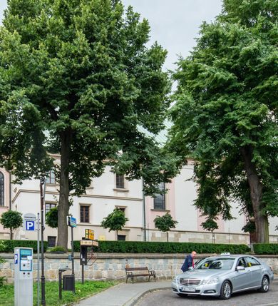 Zdjęcie nr 45: Kościół orientowany, murowany, trzynawowy. Typ halowy, z węższym, prostokątnym prezbiterium zamkniętym trójbocznie oraz z wieżą wbudowaną w zachodnią fasadę. Do prezbiterium od północy przylega zakrystia (do niej od zachodu klatka schodowa wiodąca do skarbca na piętrze), od południa natomiast kaplica Morsztynów z XVII wieku. Kaplica na planie prostokąta zamkniętego trójbocznie, z niszami w ściętych narożach, pod nią sklepiona krypta grobowa, opięta pilastrami wewnątrz i na zewnątrz. Od południa do korpusu przylega kruchta stanowiąca również kaplicę Matki Boskiej Pocieszenia. Korpus czteroprzęsłowy, nawy oddzielają arkady wsparte na filarach, pierwsze stanowią podparcie dla chóru. Nad nawami i prezbiterium strop imitujący sklepienie, na którym malowana dekoracja imitująca gurty, plafony oraz stiuki. Dekoracja ścian powtarza podziały wyznaczone przez arkady, namalowano na nich pilastry podtrzymujące belkowanie. W prezbiterium dwa okna usytuowane niedaleko ołtarza, w nawie osiem, wszystkie w kształcie stojącego prostokąta zamkniętego półkoliście, wypełnione witrażami z dekoracją geometryczną. Główne wejście od zachodu, drugie od północy, trzecie symetrycznie od południa przez kruchtę sklepioną kopułą, kolejne trzy do prezbiterium, od południa przez zakrystię i od północy przez kruchtę. 
Fasada zachodnia na cokole, podzielona gzymsami i lizenami, z wieżą zakończoną hełmem. Na osi drzwi w kształcie stojącego prostokąta flankowane prostokątnymi oknami, powyżej trzecie, większe okno zamknięte łukiem odcinkowym; kondygnację wieńczy gzyms. Druga kondygnacja powtarza podziały pierwszej. W środkowej osi okulus, powyżej dwudzielne okno zamknięte półkoliście. Nad nim tarcza zegara, kolejne dwie na ścianach bocznych. Kondygnacja ograniczona po bokach spływali wolutowymi i obeliskami zakończonymi kulami; przechodzi w wieżę. Powyżej gzyms podtrzymywany kroksztynami. Ostatnia kondygnacja o artykulacji ramowej z balkonami z każdej strony, powyżej wieńczącego gzymsu. Pozostałe elewacje na cokole, kontynuują podziały  lizenowo-ramowe, artykulacją podkreślają okna. Kaplica Morsztynów opięta pilastrami z głowicami, prezbiterium oszkarpowane. Dach nad nawą główną, kaplicą i prezbiterium dwuspadowy, na kruchtą południową kopuła, na wieży ozdobny hełm dołem wklęsły, dekorowany wolutami. Powyżej kopuła, na której latarnia przepruta arkadami i zwieńczona przewężoną w środku kopułą zakończoną ostrosłupem z kulą i krzyżem. 
Do najcenniejszych zabytków świątyni należą m.in. zaprojektowana przez Jana Delamarsa kaplica Morsztynów dekorowana stiukami z 1693 roku autorstwa Baltazara Fontany. Wewnątrz niej warto zwrócić uwagę na osiemnastowieczny ołtarz z przedstawieniem Oblicza Chrystusa i rzeźbionym antepedium. W ołtarz Ukrzyżowania znajdujący się w północnej nawie kościoła wkomponowano gotyckie rzeźby św. Jana i Marii. 