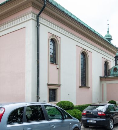 Zdjęcie nr 41: Kościół orientowany, murowany, trzynawowy. Typ halowy, z węższym, prostokątnym prezbiterium zamkniętym trójbocznie oraz z wieżą wbudowaną w zachodnią fasadę. Do prezbiterium od północy przylega zakrystia (do niej od zachodu klatka schodowa wiodąca do skarbca na piętrze), od południa natomiast kaplica Morsztynów z XVII wieku. Kaplica na planie prostokąta zamkniętego trójbocznie, z niszami w ściętych narożach, pod nią sklepiona krypta grobowa, opięta pilastrami wewnątrz i na zewnątrz. Od południa do korpusu przylega kruchta stanowiąca również kaplicę Matki Boskiej Pocieszenia. Korpus czteroprzęsłowy, nawy oddzielają arkady wsparte na filarach, pierwsze stanowią podparcie dla chóru. Nad nawami i prezbiterium strop imitujący sklepienie, na którym malowana dekoracja imitująca gurty, plafony oraz stiuki. Dekoracja ścian powtarza podziały wyznaczone przez arkady, namalowano na nich pilastry podtrzymujące belkowanie. W prezbiterium dwa okna usytuowane niedaleko ołtarza, w nawie osiem, wszystkie w kształcie stojącego prostokąta zamkniętego półkoliście, wypełnione witrażami z dekoracją geometryczną. Główne wejście od zachodu, drugie od północy, trzecie symetrycznie od południa przez kruchtę sklepioną kopułą, kolejne trzy do prezbiterium, od południa przez zakrystię i od północy przez kruchtę. 
Fasada zachodnia na cokole, podzielona gzymsami i lizenami, z wieżą zakończoną hełmem. Na osi drzwi w kształcie stojącego prostokąta flankowane prostokątnymi oknami, powyżej trzecie, większe okno zamknięte łukiem odcinkowym; kondygnację wieńczy gzyms. Druga kondygnacja powtarza podziały pierwszej. W środkowej osi okulus, powyżej dwudzielne okno zamknięte półkoliście. Nad nim tarcza zegara, kolejne dwie na ścianach bocznych. Kondygnacja ograniczona po bokach spływali wolutowymi i obeliskami zakończonymi kulami; przechodzi w wieżę. Powyżej gzyms podtrzymywany kroksztynami. Ostatnia kondygnacja o artykulacji ramowej z balkonami z każdej strony, powyżej wieńczącego gzymsu. Pozostałe elewacje na cokole, kontynuują podziały  lizenowo-ramowe, artykulacją podkreślają okna. Kaplica Morsztynów opięta pilastrami z głowicami, prezbiterium oszkarpowane. Dach nad nawą główną, kaplicą i prezbiterium dwuspadowy, na kruchtą południową kopuła, na wieży ozdobny hełm dołem wklęsły, dekorowany wolutami. Powyżej kopuła, na której latarnia przepruta arkadami i zwieńczona przewężoną w środku kopułą zakończoną ostrosłupem z kulą i krzyżem. 
Do najcenniejszych zabytków świątyni należą m.in. zaprojektowana przez Jana Delamarsa kaplica Morsztynów dekorowana stiukami z 1693 roku autorstwa Baltazara Fontany. Wewnątrz niej warto zwrócić uwagę na osiemnastowieczny ołtarz z przedstawieniem Oblicza Chrystusa i rzeźbionym antepedium. W ołtarz Ukrzyżowania znajdujący się w północnej nawie kościoła wkomponowano gotyckie rzeźby św. Jana i Marii. 