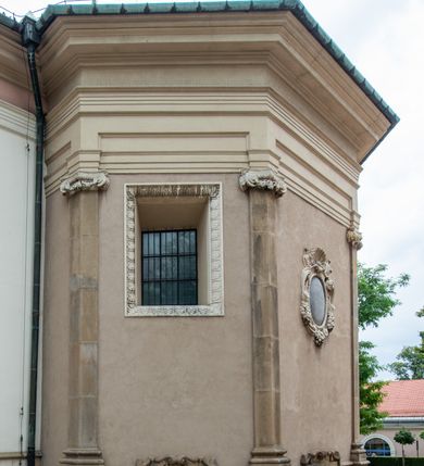 Zdjęcie nr 20: Kościół orientowany, murowany, trzynawowy. Typ halowy, z węższym, prostokątnym prezbiterium zamkniętym trójbocznie oraz z wieżą wbudowaną w zachodnią fasadę. Do prezbiterium od północy przylega zakrystia (do niej od zachodu klatka schodowa wiodąca do skarbca na piętrze), od południa natomiast kaplica Morsztynów z XVII wieku. Kaplica na planie prostokąta zamkniętego trójbocznie, z niszami w ściętych narożach, pod nią sklepiona krypta grobowa, opięta pilastrami wewnątrz i na zewnątrz. Od południa do korpusu przylega kruchta stanowiąca również kaplicę Matki Boskiej Pocieszenia. Korpus czteroprzęsłowy, nawy oddzielają arkady wsparte na filarach, pierwsze stanowią podparcie dla chóru. Nad nawami i prezbiterium strop imitujący sklepienie, na którym malowana dekoracja imitująca gurty, plafony oraz stiuki. Dekoracja ścian powtarza podziały wyznaczone przez arkady, namalowano na nich pilastry podtrzymujące belkowanie. W prezbiterium dwa okna usytuowane niedaleko ołtarza, w nawie osiem, wszystkie w kształcie stojącego prostokąta zamkniętego półkoliście, wypełnione witrażami z dekoracją geometryczną. Główne wejście od zachodu, drugie od północy, trzecie symetrycznie od południa przez kruchtę sklepioną kopułą, kolejne trzy do prezbiterium, od południa przez zakrystię i od północy przez kruchtę. 
Fasada zachodnia na cokole, podzielona gzymsami i lizenami, z wieżą zakończoną hełmem. Na osi drzwi w kształcie stojącego prostokąta flankowane prostokątnymi oknami, powyżej trzecie, większe okno zamknięte łukiem odcinkowym; kondygnację wieńczy gzyms. Druga kondygnacja powtarza podziały pierwszej. W środkowej osi okulus, powyżej dwudzielne okno zamknięte półkoliście. Nad nim tarcza zegara, kolejne dwie na ścianach bocznych. Kondygnacja ograniczona po bokach spływali wolutowymi i obeliskami zakończonymi kulami; przechodzi w wieżę. Powyżej gzyms podtrzymywany kroksztynami. Ostatnia kondygnacja o artykulacji ramowej z balkonami z każdej strony, powyżej wieńczącego gzymsu. Pozostałe elewacje na cokole, kontynuują podziały  lizenowo-ramowe, artykulacją podkreślają okna. Kaplica Morsztynów opięta pilastrami z głowicami, prezbiterium oszkarpowane. Dach nad nawą główną, kaplicą i prezbiterium dwuspadowy, na kruchtą południową kopuła, na wieży ozdobny hełm dołem wklęsły, dekorowany wolutami. Powyżej kopuła, na której latarnia przepruta arkadami i zwieńczona przewężoną w środku kopułą zakończoną ostrosłupem z kulą i krzyżem. 
Do najcenniejszych zabytków świątyni należą m.in. zaprojektowana przez Jana Delamarsa kaplica Morsztynów dekorowana stiukami z 1693 roku autorstwa Baltazara Fontany. Wewnątrz niej warto zwrócić uwagę na osiemnastowieczny ołtarz z przedstawieniem Oblicza Chrystusa i rzeźbionym antepedium. W ołtarz Ukrzyżowania znajdujący się w północnej nawie kościoła wkomponowano gotyckie rzeźby św. Jana i Marii. 