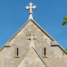 Zdjęcie nr 1: Kościół orientowany, jest budowlą murowaną z kamienia, na rzucie podłużnym. Korpus jednonawowy i dwuprzęsłowy. Do stosunkowo szerokiego, jednoprzęsłowego, zamkniętego trójbocznie prezbiterium od północy przylega zakrystia, a na osi kościoła, od zachodu kruchta. Prezbiterium przekryte jest sklepieniem krzyżowo-żebrowym, a nawa drewnianym sklepieniem kolebkowymi.  Przestrzeń prezbiterium od korpusu nawowego oddziela ostrołukowa arkada tęczowa i drewniana balustrada. Artykulację ścian na zewnątrz kościoła stanowi wieniec przypór ujmujących ściany i naroża korpusu nawowego i prezbiterium.  Do wnętrza prowadzą trzy otwory drzwiowe – jeden przez kruchtę w elewacji północnej, jeden w północnej ścianie korpusu nawowego i jeden przez zakrystię. Dwuskrzydłowe drzwi w kruchcie ujęte są portalem zamkniętym łukiem dwuramiennym, portale pozostałych otworów drzwiowych są ostrołukowe. Ściany korpusu nawowego i prezbiterium przeprute są smukłymi, ostrołukowymi oknami, w nawie wypełnionymi gomółkami, a w prezbiterium dekoracją maswerkową. W szczycie fasady para małych, wąskich okienek w kształcie stojących prostokątów, analogiczne w szczycie kruchty. Korpus nawowy, prezbiterium i zakrystia przekryte są jednym dachem dwuspadowym, wykonanym z blachy, kruchta także dachem dwuspadowym. Na połączeniu nawy i prezbiterium umieszczona jest wieżyczka na sygnaturkę, także obita blachą. Kolorystyka tynków kościoła utrzymana jest w kolorze białym, fasada i kruchta są kamienne. 