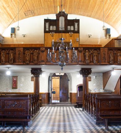 Zdjęcie nr 3: Kościół orientowany, jest budowlą murowaną z kamienia, na rzucie podłużnym. Korpus jednonawowy i dwuprzęsłowy. Do stosunkowo szerokiego, jednoprzęsłowego, zamkniętego trójbocznie prezbiterium od północy przylega zakrystia, a na osi kościoła, od zachodu kruchta. Prezbiterium przekryte jest sklepieniem krzyżowo-żebrowym, a nawa drewnianym sklepieniem kolebkowymi.  Przestrzeń prezbiterium od korpusu nawowego oddziela ostrołukowa arkada tęczowa i drewniana balustrada. Artykulację ścian na zewnątrz kościoła stanowi wieniec przypór ujmujących ściany i naroża korpusu nawowego i prezbiterium.  Do wnętrza prowadzą trzy otwory drzwiowe – jeden przez kruchtę w elewacji północnej, jeden w północnej ścianie korpusu nawowego i jeden przez zakrystię. Dwuskrzydłowe drzwi w kruchcie ujęte są portalem zamkniętym łukiem dwuramiennym, portale pozostałych otworów drzwiowych są ostrołukowe. Ściany korpusu nawowego i prezbiterium przeprute są smukłymi, ostrołukowymi oknami, w nawie wypełnionymi gomółkami, a w prezbiterium dekoracją maswerkową. W szczycie fasady para małych, wąskich okienek w kształcie stojących prostokątów, analogiczne w szczycie kruchty. Korpus nawowy, prezbiterium i zakrystia przekryte są jednym dachem dwuspadowym, wykonanym z blachy, kruchta także dachem dwuspadowym. Na połączeniu nawy i prezbiterium umieszczona jest wieżyczka na sygnaturkę, także obita blachą. Kolorystyka tynków kościoła utrzymana jest w kolorze białym, fasada i kruchta są kamienne. 