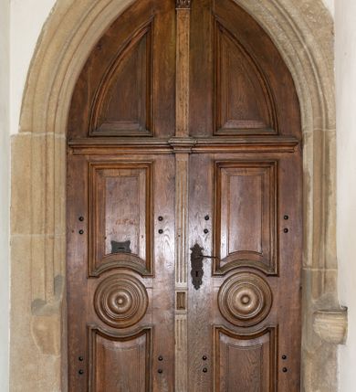 Zdjęcie nr 2: Kościół orientowany, jest budowlą murowaną z kamienia, na rzucie podłużnym. Korpus jednonawowy i dwuprzęsłowy. Do stosunkowo szerokiego, jednoprzęsłowego, zamkniętego trójbocznie prezbiterium od północy przylega zakrystia, a na osi kościoła, od zachodu kruchta. Prezbiterium przekryte jest sklepieniem krzyżowo-żebrowym, a nawa drewnianym sklepieniem kolebkowymi.  Przestrzeń prezbiterium od korpusu nawowego oddziela ostrołukowa arkada tęczowa i drewniana balustrada. Artykulację ścian na zewnątrz kościoła stanowi wieniec przypór ujmujących ściany i naroża korpusu nawowego i prezbiterium.  Do wnętrza prowadzą trzy otwory drzwiowe – jeden przez kruchtę w elewacji północnej, jeden w północnej ścianie korpusu nawowego i jeden przez zakrystię. Dwuskrzydłowe drzwi w kruchcie ujęte są portalem zamkniętym łukiem dwuramiennym, portale pozostałych otworów drzwiowych są ostrołukowe. Ściany korpusu nawowego i prezbiterium przeprute są smukłymi, ostrołukowymi oknami, w nawie wypełnionymi gomółkami, a w prezbiterium dekoracją maswerkową. W szczycie fasady para małych, wąskich okienek w kształcie stojących prostokątów, analogiczne w szczycie kruchty. Korpus nawowy, prezbiterium i zakrystia przekryte są jednym dachem dwuspadowym, wykonanym z blachy, kruchta także dachem dwuspadowym. Na połączeniu nawy i prezbiterium umieszczona jest wieżyczka na sygnaturkę, także obita blachą. Kolorystyka tynków kościoła utrzymana jest w kolorze białym, fasada i kruchta są kamienne. 