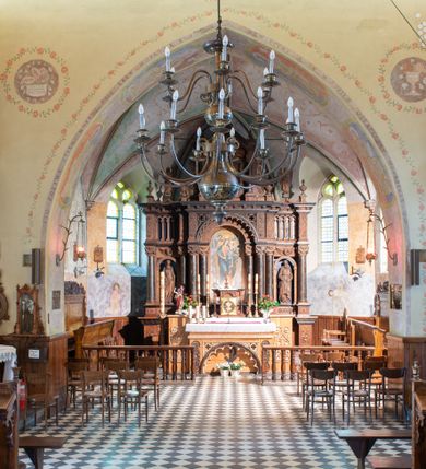 Zdjęcie nr 10: Kościół orientowany, jest budowlą murowaną z kamienia, na rzucie podłużnym. Korpus jednonawowy i dwuprzęsłowy. Do stosunkowo szerokiego, jednoprzęsłowego, zamkniętego trójbocznie prezbiterium od północy przylega zakrystia, a na osi kościoła, od zachodu kruchta. Prezbiterium przekryte jest sklepieniem krzyżowo-żebrowym, a nawa drewnianym sklepieniem kolebkowymi.  Przestrzeń prezbiterium od korpusu nawowego oddziela ostrołukowa arkada tęczowa i drewniana balustrada. Artykulację ścian na zewnątrz kościoła stanowi wieniec przypór ujmujących ściany i naroża korpusu nawowego i prezbiterium.  Do wnętrza prowadzą trzy otwory drzwiowe – jeden przez kruchtę w elewacji północnej, jeden w północnej ścianie korpusu nawowego i jeden przez zakrystię. Dwuskrzydłowe drzwi w kruchcie ujęte są portalem zamkniętym łukiem dwuramiennym, portale pozostałych otworów drzwiowych są ostrołukowe. Ściany korpusu nawowego i prezbiterium przeprute są smukłymi, ostrołukowymi oknami, w nawie wypełnionymi gomółkami, a w prezbiterium dekoracją maswerkową. W szczycie fasady para małych, wąskich okienek w kształcie stojących prostokątów, analogiczne w szczycie kruchty. Korpus nawowy, prezbiterium i zakrystia przekryte są jednym dachem dwuspadowym, wykonanym z blachy, kruchta także dachem dwuspadowym. Na połączeniu nawy i prezbiterium umieszczona jest wieżyczka na sygnaturkę, także obita blachą. Kolorystyka tynków kościoła utrzymana jest w kolorze białym, fasada i kruchta są kamienne. 