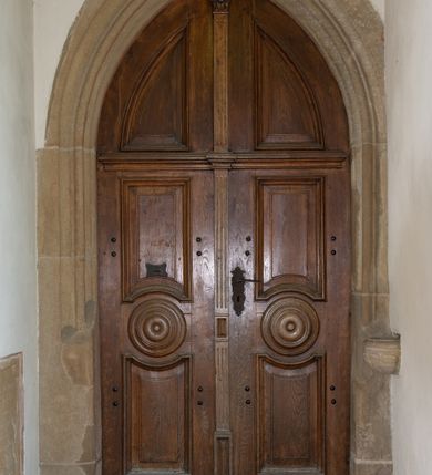 Zdjęcie nr 15: Kościół orientowany, jest budowlą murowaną z kamienia, na rzucie podłużnym. Korpus jednonawowy i dwuprzęsłowy. Do stosunkowo szerokiego, jednoprzęsłowego, zamkniętego trójbocznie prezbiterium od północy przylega zakrystia, a na osi kościoła, od zachodu kruchta. Prezbiterium przekryte jest sklepieniem krzyżowo-żebrowym, a nawa drewnianym sklepieniem kolebkowymi.  Przestrzeń prezbiterium od korpusu nawowego oddziela ostrołukowa arkada tęczowa i drewniana balustrada. Artykulację ścian na zewnątrz kościoła stanowi wieniec przypór ujmujących ściany i naroża korpusu nawowego i prezbiterium.  Do wnętrza prowadzą trzy otwory drzwiowe – jeden przez kruchtę w elewacji północnej, jeden w północnej ścianie korpusu nawowego i jeden przez zakrystię. Dwuskrzydłowe drzwi w kruchcie ujęte są portalem zamkniętym łukiem dwuramiennym, portale pozostałych otworów drzwiowych są ostrołukowe. Ściany korpusu nawowego i prezbiterium przeprute są smukłymi, ostrołukowymi oknami, w nawie wypełnionymi gomółkami, a w prezbiterium dekoracją maswerkową. W szczycie fasady para małych, wąskich okienek w kształcie stojących prostokątów, analogiczne w szczycie kruchty. Korpus nawowy, prezbiterium i zakrystia przekryte są jednym dachem dwuspadowym, wykonanym z blachy, kruchta także dachem dwuspadowym. Na połączeniu nawy i prezbiterium umieszczona jest wieżyczka na sygnaturkę, także obita blachą. Kolorystyka tynków kościoła utrzymana jest w kolorze białym, fasada i kruchta są kamienne. 