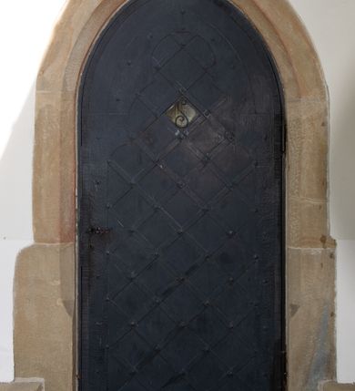 Zdjęcie nr 14: Kościół orientowany, jest budowlą murowaną z kamienia, na rzucie podłużnym. Korpus jednonawowy i dwuprzęsłowy. Do stosunkowo szerokiego, jednoprzęsłowego, zamkniętego trójbocznie prezbiterium od północy przylega zakrystia, a na osi kościoła, od zachodu kruchta. Prezbiterium przekryte jest sklepieniem krzyżowo-żebrowym, a nawa drewnianym sklepieniem kolebkowymi.  Przestrzeń prezbiterium od korpusu nawowego oddziela ostrołukowa arkada tęczowa i drewniana balustrada. Artykulację ścian na zewnątrz kościoła stanowi wieniec przypór ujmujących ściany i naroża korpusu nawowego i prezbiterium.  Do wnętrza prowadzą trzy otwory drzwiowe – jeden przez kruchtę w elewacji północnej, jeden w północnej ścianie korpusu nawowego i jeden przez zakrystię. Dwuskrzydłowe drzwi w kruchcie ujęte są portalem zamkniętym łukiem dwuramiennym, portale pozostałych otworów drzwiowych są ostrołukowe. Ściany korpusu nawowego i prezbiterium przeprute są smukłymi, ostrołukowymi oknami, w nawie wypełnionymi gomółkami, a w prezbiterium dekoracją maswerkową. W szczycie fasady para małych, wąskich okienek w kształcie stojących prostokątów, analogiczne w szczycie kruchty. Korpus nawowy, prezbiterium i zakrystia przekryte są jednym dachem dwuspadowym, wykonanym z blachy, kruchta także dachem dwuspadowym. Na połączeniu nawy i prezbiterium umieszczona jest wieżyczka na sygnaturkę, także obita blachą. Kolorystyka tynków kościoła utrzymana jest w kolorze białym, fasada i kruchta są kamienne. 