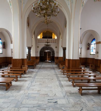 Zdjęcie nr 13: Kościół jest położony w centrum wsi, na północ od główne drogi we wsi, na placu otoczonym kamiennym murem, nakrytym betonowym daszkiem, obsadzony ozdobnym drzewostanem. Wejście na plac kościelny prowadzi przez bramę od południa i wąską furtkę od zachodu. Kościół jest budowlą założoną na planie krzyża łacińskiego, murowaną, skierowaną na północ, trójnawową z transeptem i prezbiterium zakończonym wielobocznie. Wewnątrz dwuprzęsłowe nawy oddzielone są ostrołukowymi arkadami wspartymi na zdwojonych filarach oraz na parze kolumn pośrodku świątyni. Podpory wspierają sklepienie krzyżowo-żebrowe. Od fasady dostawiona masywna wieża na planie prostokąta, zwężająca się ku górze, nakryta namiotowym daszkiem i zwieńczona krzyżem. Wejście południowe w formie prostokątnego portalu, ujętego w dużą ostrołukową arkadę wykonaną z kamiennej okładziny. Powyżej na tle trójdzielnego okna ustawiona jest figura Chrystusa. Pomiędzy zachodnim ramieniem transeptu, a prezbiterium dostawiona zakrystia z wejściem od północy, analogicznie po drugiej stronie kościoła kaplica Najświętszego Serca Pana Jezusa. Nad skrzyżowaniem ramion transeptu umieszczona jest ażurowa wieżyczka na sygnaturkę. Całość opięta szkarpami. Detale dekoracyjne, takie jak narożniki, portale, gzymsy i obramowania okien wykonane z piaskowca. Do świątyni prowadzi też zachodni przedsionek.