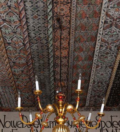 Zdjęcie nr 27: Kościół drewniany, orientowany, składający się z babińca, nawy głównej z przylegającą do niej od północy kaplicą boczną i kruchtą od południa oraz prezbiterium z zakrystią od północy. Prezbiterium i nawa w konstrukcji zrębowej, wieża, soboty i kruchta w słupowej. Kościół jednonawowy, nawa prawie kwadratowa, prezbiterium prostokątne, zamknięte prosto, oddzielone ścianą tęczową. Otwór tęczowy zamknięty łukiem dwuramiennym z biegnącą w poprzek grubą belką. Ściany gładkie, pokryte dekoracją malarską imitującą poziomo ułożone belki z uszczelniającymi je kiczkami, scenami figuralnymi, zacheuszkami i pasami ornamentalnymi. W nawie od zachodu chór muzyczny wsparty na dwóch, profilowanych słupach, z parapetem wybrzuszonym pośrodku; z dekoracją malarską o motywach geometryczno-roślinnych. Nawa i prezbiterium naryte pozornym sklepieniem z pułapami lekko zaokrąglonymi po bokach. Na całości przekrycia dekoracja malarska. W prezbiterium są to postacie aniołów wśród stylizowanych kwiatów na stropie adorujących monogram maryjny, nawę dekorują motywy roślinne. Anioły zdobią również sklepienie kaplicy. Strop babińca oraz fragmenty prezbiterium pokrywa oryginalna dekoracja patronowa złożona z motywów geometrycznych oraz figuralnych. W nawie głównej trzy okna, w prezbiterium i babińcu po dwa – od południa, kolejne do zakrystii; zamknięte łukiem dwuspadowym. Główne wejście od zachodu, drugie przez kruchtę od południa, trzecie do zakrystii. Portal południowy ostrołukowy, dekorowany ornamentem sznurowym, portal do zakrystii zamknięty łukiem w ośli grzbiet. Od zachodu kwadratowa wieża o pochyłych ścianach, z nadwieszoną izbicą, zwieńczona czteropołaciowym, ostrosłupowym hełmem gontowym. Izbica wieży oszalowana dookoła deskami zakończonymi u dołu ozdobnie wyrzynaną koronką. Od południa i wschodu soboty, czyli rodzaj podcieni,  w pozostałych miejscach gontowy kołnierz. Ściany świątyni oraz kaplicy są od zewnątrz szalowane deskami, wieża oraz przedsionek obite są gontem. Dachy i zadaszenia sobot pokryte gontem, kopuła kaplicy oraz wieżyczka na sygnaturkę pokryta blachą. 