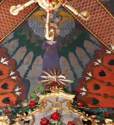 Zdjęcie nr 39: Kościół drewniany, orientowany, składający się z babińca, nawy głównej z przylegającą do niej od północy kaplicą boczną i kruchtą od południa oraz prezbiterium z zakrystią od północy. Prezbiterium i nawa w konstrukcji zrębowej, wieża, soboty i kruchta w słupowej. Kościół jednonawowy, nawa prawie kwadratowa, prezbiterium prostokątne, zamknięte prosto, oddzielone ścianą tęczową. Otwór tęczowy zamknięty łukiem dwuramiennym z biegnącą w poprzek grubą belką. Ściany gładkie, pokryte dekoracją malarską imitującą poziomo ułożone belki z uszczelniającymi je kiczkami, scenami figuralnymi, zacheuszkami i pasami ornamentalnymi. W nawie od zachodu chór muzyczny wsparty na dwóch, profilowanych słupach, z parapetem wybrzuszonym pośrodku; z dekoracją malarską o motywach geometryczno-roślinnych. Nawa i prezbiterium naryte pozornym sklepieniem z pułapami lekko zaokrąglonymi po bokach. Na całości przekrycia dekoracja malarska. W prezbiterium są to postacie aniołów wśród stylizowanych kwiatów na stropie adorujących monogram maryjny, nawę dekorują motywy roślinne. Anioły zdobią również sklepienie kaplicy. Strop babińca oraz fragmenty prezbiterium pokrywa oryginalna dekoracja patronowa złożona z motywów geometrycznych oraz figuralnych. W nawie głównej trzy okna, w prezbiterium i babińcu po dwa – od południa, kolejne do zakrystii; zamknięte łukiem dwuspadowym. Główne wejście od zachodu, drugie przez kruchtę od południa, trzecie do zakrystii. Portal południowy ostrołukowy, dekorowany ornamentem sznurowym, portal do zakrystii zamknięty łukiem w ośli grzbiet. Od zachodu kwadratowa wieża o pochyłych ścianach, z nadwieszoną izbicą, zwieńczona czteropołaciowym, ostrosłupowym hełmem gontowym. Izbica wieży oszalowana dookoła deskami zakończonymi u dołu ozdobnie wyrzynaną koronką. Od południa i wschodu soboty, czyli rodzaj podcieni,  w pozostałych miejscach gontowy kołnierz. Ściany świątyni oraz kaplicy są od zewnątrz szalowane deskami, wieża oraz przedsionek obite są gontem. Dachy i zadaszenia sobot pokryte gontem, kopuła kaplicy oraz wieżyczka na sygnaturkę pokryta blachą. 
