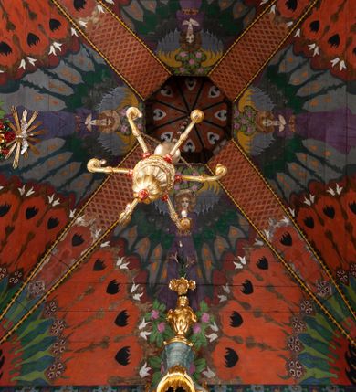 Zdjęcie nr 36: Kościół drewniany, orientowany, składający się z babińca, nawy głównej z przylegającą do niej od północy kaplicą boczną i kruchtą od południa oraz prezbiterium z zakrystią od północy. Prezbiterium i nawa w konstrukcji zrębowej, wieża, soboty i kruchta w słupowej. Kościół jednonawowy, nawa prawie kwadratowa, prezbiterium prostokątne, zamknięte prosto, oddzielone ścianą tęczową. Otwór tęczowy zamknięty łukiem dwuramiennym z biegnącą w poprzek grubą belką. Ściany gładkie, pokryte dekoracją malarską imitującą poziomo ułożone belki z uszczelniającymi je kiczkami, scenami figuralnymi, zacheuszkami i pasami ornamentalnymi. W nawie od zachodu chór muzyczny wsparty na dwóch, profilowanych słupach, z parapetem wybrzuszonym pośrodku; z dekoracją malarską o motywach geometryczno-roślinnych. Nawa i prezbiterium naryte pozornym sklepieniem z pułapami lekko zaokrąglonymi po bokach. Na całości przekrycia dekoracja malarska. W prezbiterium są to postacie aniołów wśród stylizowanych kwiatów na stropie adorujących monogram maryjny, nawę dekorują motywy roślinne. Anioły zdobią również sklepienie kaplicy. Strop babińca oraz fragmenty prezbiterium pokrywa oryginalna dekoracja patronowa złożona z motywów geometrycznych oraz figuralnych. W nawie głównej trzy okna, w prezbiterium i babińcu po dwa – od południa, kolejne do zakrystii; zamknięte łukiem dwuspadowym. Główne wejście od zachodu, drugie przez kruchtę od południa, trzecie do zakrystii. Portal południowy ostrołukowy, dekorowany ornamentem sznurowym, portal do zakrystii zamknięty łukiem w ośli grzbiet. Od zachodu kwadratowa wieża o pochyłych ścianach, z nadwieszoną izbicą, zwieńczona czteropołaciowym, ostrosłupowym hełmem gontowym. Izbica wieży oszalowana dookoła deskami zakończonymi u dołu ozdobnie wyrzynaną koronką. Od południa i wschodu soboty, czyli rodzaj podcieni,  w pozostałych miejscach gontowy kołnierz. Ściany świątyni oraz kaplicy są od zewnątrz szalowane deskami, wieża oraz przedsionek obite są gontem. Dachy i zadaszenia sobot pokryte gontem, kopuła kaplicy oraz wieżyczka na sygnaturkę pokryta blachą. 