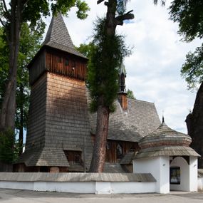 Zdjęcie nr 1: Kościół drewniany, orientowany, składający się z babińca, nawy głównej z przylegającą do niej od północy kaplicą boczną i kruchtą od południa oraz prezbiterium z zakrystią od północy. Prezbiterium i nawa w konstrukcji zrębowej, wieża, soboty i kruchta w słupowej. Kościół jednonawowy, nawa prawie kwadratowa, prezbiterium prostokątne, zamknięte prosto, oddzielone ścianą tęczową. Otwór tęczowy zamknięty łukiem dwuramiennym z biegnącą w poprzek grubą belką. Ściany gładkie, pokryte dekoracją malarską imitującą poziomo ułożone belki z uszczelniającymi je kiczkami, scenami figuralnymi, zacheuszkami i pasami ornamentalnymi. W nawie od zachodu chór muzyczny wsparty na dwóch, profilowanych słupach, z parapetem wybrzuszonym pośrodku; z dekoracją malarską o motywach geometryczno-roślinnych. Nawa i prezbiterium naryte pozornym sklepieniem z pułapami lekko zaokrąglonymi po bokach. Na całości przekrycia dekoracja malarska. W prezbiterium są to postacie aniołów wśród stylizowanych kwiatów na stropie adorujących monogram maryjny, nawę dekorują motywy roślinne. Anioły zdobią również sklepienie kaplicy. Strop babińca oraz fragmenty prezbiterium pokrywa oryginalna dekoracja patronowa złożona z motywów geometrycznych oraz figuralnych. W nawie głównej trzy okna, w prezbiterium i babińcu po dwa – od południa, kolejne do zakrystii; zamknięte łukiem dwuspadowym. Główne wejście od zachodu, drugie przez kruchtę od południa, trzecie do zakrystii. Portal południowy ostrołukowy, dekorowany ornamentem sznurowym, portal do zakrystii zamknięty łukiem w ośli grzbiet. Od zachodu kwadratowa wieża o pochyłych ścianach, z nadwieszoną izbicą, zwieńczona czteropołaciowym, ostrosłupowym hełmem gontowym. Izbica wieży oszalowana dookoła deskami zakończonymi u dołu ozdobnie wyrzynaną koronką. Od południa i wschodu soboty, czyli rodzaj podcieni,  w pozostałych miejscach gontowy kołnierz. Ściany świątyni oraz kaplicy są od zewnątrz szalowane deskami, wieża oraz przedsionek obite są gontem. Dachy i zadaszenia sobot pokryte gontem, kopuła kaplicy oraz wieżyczka na sygnaturkę pokryta blachą. 