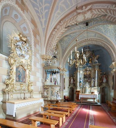 Zdjęcie nr 7: Kościół św. Walentego w Krempachach usytuowany jest na skraju wsi, na północ od drogi prowadzącej z Frydmanu do Łopusznej. Teren przykościelny jest otoczony kamiennym, murem nakrytym drewnianym daszkiem, jednospadowym, nachylonym na zewnątrz. W obrębie placu przykościelnego znajduje się cmentarz.
Kościół jest orientowany, murowany, otynkowany, jednonawowy z prezbiterium zamkniętym półkoliście. Wewnątrz sklepienia kolebkowe z lunetami. Prezbiterium oddzielone od nawy ścianą arkady tęczowej o półkolistym łuku, zdobionym napisem: „ERCETA SUPREMI IN NUMINIS / MAIOREM GLORIAM / DIVI VALENTINI EPI: ET MART. PAT/RONI CADUCORUM HONOREM / AN(N)O 1761 / RENO[VATUM] 1893”. Do prezbiterium przylega od północny zakrystia na planie prostokąta. Z kolei przy południowej ścianie nawy znajduje się kruchta z wejściem do świątyni ozdobiona wklęsło-wypukłym przyczółkiem. Na zachodniej ścianie nawy chór muzyczny wsparty jest na dwóch kolumnach z dostępem drewnianymi schodami od strony południowej nawy. Na balustradzie napis: „ABIICITE OPERA TENEBRARUM / ET INDUAMINI ARMA LUCIS”.
Wnętrze artykułowe zdwojonymi pilastrami podtrzymującymi gurty sklepienne. Otwory okienne umieszczone są w południowych i północnych ścianach nawy oraz prezbiterium – prostokątne, zamknięte półkoliście, wypełnione witrażami. Wejście do zakrystii od strony prezbiterium prowadzi poprzez kamienny portal z iluzjonistycznie malowanymi kanelowanymi kolumnami o korynckich kapitelach, wspierającymi profilowany gzyms, przyczółek trójkątny z wpisanym w polu Okiem Opatrzności.
Zewnętrzne elewacje bez dekoracji, skromne, otynkowane, oszkarpowane w nawie. Prezbiterium i nawa nakryte jednym, czterospadowym dachem z wieżą na sygnaturkę na zachodnim zakończeniu nawy. Do zachodniej fasady kościoła dostawiona jest kruchta na planie prostokąta, nakryta dwuspadowym daszkiem, od przodu ujęta przyczółkiem w kształcie wklęsło-wypukłym z uskokami. Z trzech stron kruchty prostokątne otwory wejściowe zamknięte półkoliście. Do kościoła prowadzi wejście przez kruchtę zachodnią oraz przez kruchtę od południa i jedno od strony północnej przez zakrystię. Zewnętrze obramienia okienne roślinną dekoracją sztukatorską. 