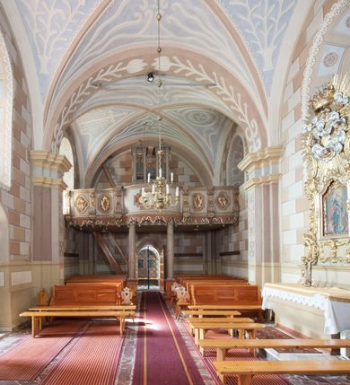 Zdjęcie nr 9: Kościół św. Walentego w Krempachach usytuowany jest na skraju wsi, na północ od drogi prowadzącej z Frydmanu do Łopusznej. Teren przykościelny jest otoczony kamiennym, murem nakrytym drewnianym daszkiem, jednospadowym, nachylonym na zewnątrz. W obrębie placu przykościelnego znajduje się cmentarz.
Kościół jest orientowany, murowany, otynkowany, jednonawowy z prezbiterium zamkniętym półkoliście. Wewnątrz sklepienia kolebkowe z lunetami. Prezbiterium oddzielone od nawy ścianą arkady tęczowej o półkolistym łuku, zdobionym napisem: „ERCETA SUPREMI IN NUMINIS / MAIOREM GLORIAM / DIVI VALENTINI EPI: ET MART. PAT/RONI CADUCORUM HONOREM / AN(N)O 1761 / RENO[VATUM] 1893”. Do prezbiterium przylega od północny zakrystia na planie prostokąta. Z kolei przy południowej ścianie nawy znajduje się kruchta z wejściem do świątyni ozdobiona wklęsło-wypukłym przyczółkiem. Na zachodniej ścianie nawy chór muzyczny wsparty jest na dwóch kolumnach z dostępem drewnianymi schodami od strony południowej nawy. Na balustradzie napis: „ABIICITE OPERA TENEBRARUM / ET INDUAMINI ARMA LUCIS”.
Wnętrze artykułowe zdwojonymi pilastrami podtrzymującymi gurty sklepienne. Otwory okienne umieszczone są w południowych i północnych ścianach nawy oraz prezbiterium – prostokątne, zamknięte półkoliście, wypełnione witrażami. Wejście do zakrystii od strony prezbiterium prowadzi poprzez kamienny portal z iluzjonistycznie malowanymi kanelowanymi kolumnami o korynckich kapitelach, wspierającymi profilowany gzyms, przyczółek trójkątny z wpisanym w polu Okiem Opatrzności.
Zewnętrzne elewacje bez dekoracji, skromne, otynkowane, oszkarpowane w nawie. Prezbiterium i nawa nakryte jednym, czterospadowym dachem z wieżą na sygnaturkę na zachodnim zakończeniu nawy. Do zachodniej fasady kościoła dostawiona jest kruchta na planie prostokąta, nakryta dwuspadowym daszkiem, od przodu ujęta przyczółkiem w kształcie wklęsło-wypukłym z uskokami. Z trzech stron kruchty prostokątne otwory wejściowe zamknięte półkoliście. Do kościoła prowadzi wejście przez kruchtę zachodnią oraz przez kruchtę od południa i jedno od strony północnej przez zakrystię. Zewnętrze obramienia okienne roślinną dekoracją sztukatorską. 