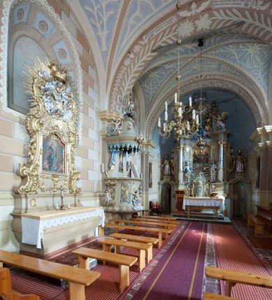 Zdjęcie nr 6: Kościół św. Walentego w Krempachach usytuowany jest na skraju wsi, na północ od drogi prowadzącej z Frydmanu do Łopusznej. Teren przykościelny jest otoczony kamiennym, murem nakrytym drewnianym daszkiem, jednospadowym, nachylonym na zewnątrz. W obrębie placu przykościelnego znajduje się cmentarz.
Kościół jest orientowany, murowany, otynkowany, jednonawowy z prezbiterium zamkniętym półkoliście. Wewnątrz sklepienia kolebkowe z lunetami. Prezbiterium oddzielone od nawy ścianą arkady tęczowej o półkolistym łuku, zdobionym napisem: „ERCETA SUPREMI IN NUMINIS / MAIOREM GLORIAM / DIVI VALENTINI EPI: ET MART. PAT/RONI CADUCORUM HONOREM / AN(N)O 1761 / RENO[VATUM] 1893”. Do prezbiterium przylega od północny zakrystia na planie prostokąta. Z kolei przy południowej ścianie nawy znajduje się kruchta z wejściem do świątyni ozdobiona wklęsło-wypukłym przyczółkiem. Na zachodniej ścianie nawy chór muzyczny wsparty jest na dwóch kolumnach z dostępem drewnianymi schodami od strony południowej nawy. Na balustradzie napis: „ABIICITE OPERA TENEBRARUM / ET INDUAMINI ARMA LUCIS”.
Wnętrze artykułowe zdwojonymi pilastrami podtrzymującymi gurty sklepienne. Otwory okienne umieszczone są w południowych i północnych ścianach nawy oraz prezbiterium – prostokątne, zamknięte półkoliście, wypełnione witrażami. Wejście do zakrystii od strony prezbiterium prowadzi poprzez kamienny portal z iluzjonistycznie malowanymi kanelowanymi kolumnami o korynckich kapitelach, wspierającymi profilowany gzyms, przyczółek trójkątny z wpisanym w polu Okiem Opatrzności.
Zewnętrzne elewacje bez dekoracji, skromne, otynkowane, oszkarpowane w nawie. Prezbiterium i nawa nakryte jednym, czterospadowym dachem z wieżą na sygnaturkę na zachodnim zakończeniu nawy. Do zachodniej fasady kościoła dostawiona jest kruchta na planie prostokąta, nakryta dwuspadowym daszkiem, od przodu ujęta przyczółkiem w kształcie wklęsło-wypukłym z uskokami. Z trzech stron kruchty prostokątne otwory wejściowe zamknięte półkoliście. Do kościoła prowadzi wejście przez kruchtę zachodnią oraz przez kruchtę od południa i jedno od strony północnej przez zakrystię. Zewnętrze obramienia okienne roślinną dekoracją sztukatorską. 