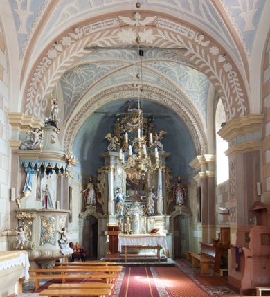 Zdjęcie nr 4: Kościół św. Walentego w Krempachach usytuowany jest na skraju wsi, na północ od drogi prowadzącej z Frydmanu do Łopusznej. Teren przykościelny jest otoczony kamiennym, murem nakrytym drewnianym daszkiem, jednospadowym, nachylonym na zewnątrz. W obrębie placu przykościelnego znajduje się cmentarz.
Kościół jest orientowany, murowany, otynkowany, jednonawowy z prezbiterium zamkniętym półkoliście. Wewnątrz sklepienia kolebkowe z lunetami. Prezbiterium oddzielone od nawy ścianą arkady tęczowej o półkolistym łuku, zdobionym napisem: „ERCETA SUPREMI IN NUMINIS / MAIOREM GLORIAM / DIVI VALENTINI EPI: ET MART. PAT/RONI CADUCORUM HONOREM / AN(N)O 1761 / RENO[VATUM] 1893”. Do prezbiterium przylega od północny zakrystia na planie prostokąta. Z kolei przy południowej ścianie nawy znajduje się kruchta z wejściem do świątyni ozdobiona wklęsło-wypukłym przyczółkiem. Na zachodniej ścianie nawy chór muzyczny wsparty jest na dwóch kolumnach z dostępem drewnianymi schodami od strony południowej nawy. Na balustradzie napis: „ABIICITE OPERA TENEBRARUM / ET INDUAMINI ARMA LUCIS”.
Wnętrze artykułowe zdwojonymi pilastrami podtrzymującymi gurty sklepienne. Otwory okienne umieszczone są w południowych i północnych ścianach nawy oraz prezbiterium – prostokątne, zamknięte półkoliście, wypełnione witrażami. Wejście do zakrystii od strony prezbiterium prowadzi poprzez kamienny portal z iluzjonistycznie malowanymi kanelowanymi kolumnami o korynckich kapitelach, wspierającymi profilowany gzyms, przyczółek trójkątny z wpisanym w polu Okiem Opatrzności.
Zewnętrzne elewacje bez dekoracji, skromne, otynkowane, oszkarpowane w nawie. Prezbiterium i nawa nakryte jednym, czterospadowym dachem z wieżą na sygnaturkę na zachodnim zakończeniu nawy. Do zachodniej fasady kościoła dostawiona jest kruchta na planie prostokąta, nakryta dwuspadowym daszkiem, od przodu ujęta przyczółkiem w kształcie wklęsło-wypukłym z uskokami. Z trzech stron kruchty prostokątne otwory wejściowe zamknięte półkoliście. Do kościoła prowadzi wejście przez kruchtę zachodnią oraz przez kruchtę od południa i jedno od strony północnej przez zakrystię. Zewnętrze obramienia okienne roślinną dekoracją sztukatorską. 