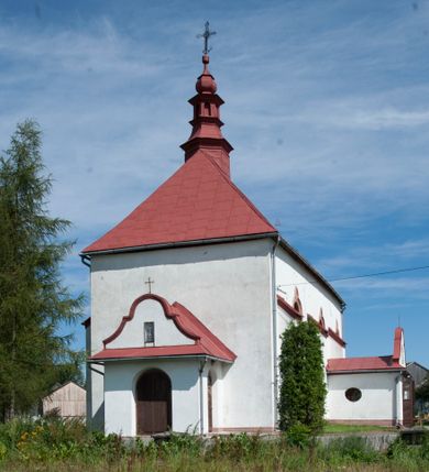 Zdjęcie nr 2: Kościół św. Walentego w Krempachach usytuowany jest na skraju wsi, na północ od drogi prowadzącej z Frydmanu do Łopusznej. Teren przykościelny jest otoczony kamiennym, murem nakrytym drewnianym daszkiem, jednospadowym, nachylonym na zewnątrz. W obrębie placu przykościelnego znajduje się cmentarz.
Kościół jest orientowany, murowany, otynkowany, jednonawowy z prezbiterium zamkniętym półkoliście. Wewnątrz sklepienia kolebkowe z lunetami. Prezbiterium oddzielone od nawy ścianą arkady tęczowej o półkolistym łuku, zdobionym napisem: „ERCETA SUPREMI IN NUMINIS / MAIOREM GLORIAM / DIVI VALENTINI EPI: ET MART. PAT/RONI CADUCORUM HONOREM / AN(N)O 1761 / RENO[VATUM] 1893”. Do prezbiterium przylega od północny zakrystia na planie prostokąta. Z kolei przy południowej ścianie nawy znajduje się kruchta z wejściem do świątyni ozdobiona wklęsło-wypukłym przyczółkiem. Na zachodniej ścianie nawy chór muzyczny wsparty jest na dwóch kolumnach z dostępem drewnianymi schodami od strony południowej nawy. Na balustradzie napis: „ABIICITE OPERA TENEBRARUM / ET INDUAMINI ARMA LUCIS”.
Wnętrze artykułowe zdwojonymi pilastrami podtrzymującymi gurty sklepienne. Otwory okienne umieszczone są w południowych i północnych ścianach nawy oraz prezbiterium – prostokątne, zamknięte półkoliście, wypełnione witrażami. Wejście do zakrystii od strony prezbiterium prowadzi poprzez kamienny portal z iluzjonistycznie malowanymi kanelowanymi kolumnami o korynckich kapitelach, wspierającymi profilowany gzyms, przyczółek trójkątny z wpisanym w polu Okiem Opatrzności.
Zewnętrzne elewacje bez dekoracji, skromne, otynkowane, oszkarpowane w nawie. Prezbiterium i nawa nakryte jednym, czterospadowym dachem z wieżą na sygnaturkę na zachodnim zakończeniu nawy. Do zachodniej fasady kościoła dostawiona jest kruchta na planie prostokąta, nakryta dwuspadowym daszkiem, od przodu ujęta przyczółkiem w kształcie wklęsło-wypukłym z uskokami. Z trzech stron kruchty prostokątne otwory wejściowe zamknięte półkoliście. Do kościoła prowadzi wejście przez kruchtę zachodnią oraz przez kruchtę od południa i jedno od strony północnej przez zakrystię. Zewnętrze obramienia okienne roślinną dekoracją sztukatorską. 