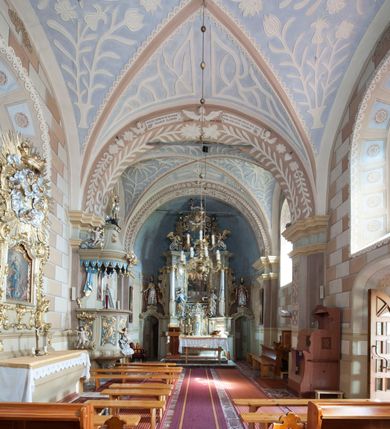 Zdjęcie nr 3: Kościół św. Walentego w Krempachach usytuowany jest na skraju wsi, na północ od drogi prowadzącej z Frydmanu do Łopusznej. Teren przykościelny jest otoczony kamiennym, murem nakrytym drewnianym daszkiem, jednospadowym, nachylonym na zewnątrz. W obrębie placu przykościelnego znajduje się cmentarz.
Kościół jest orientowany, murowany, otynkowany, jednonawowy z prezbiterium zamkniętym półkoliście. Wewnątrz sklepienia kolebkowe z lunetami. Prezbiterium oddzielone od nawy ścianą arkady tęczowej o półkolistym łuku, zdobionym napisem: „ERCETA SUPREMI IN NUMINIS / MAIOREM GLORIAM / DIVI VALENTINI EPI: ET MART. PAT/RONI CADUCORUM HONOREM / AN(N)O 1761 / RENO[VATUM] 1893”. Do prezbiterium przylega od północny zakrystia na planie prostokąta. Z kolei przy południowej ścianie nawy znajduje się kruchta z wejściem do świątyni ozdobiona wklęsło-wypukłym przyczółkiem. Na zachodniej ścianie nawy chór muzyczny wsparty jest na dwóch kolumnach z dostępem drewnianymi schodami od strony południowej nawy. Na balustradzie napis: „ABIICITE OPERA TENEBRARUM / ET INDUAMINI ARMA LUCIS”.
Wnętrze artykułowe zdwojonymi pilastrami podtrzymującymi gurty sklepienne. Otwory okienne umieszczone są w południowych i północnych ścianach nawy oraz prezbiterium – prostokątne, zamknięte półkoliście, wypełnione witrażami. Wejście do zakrystii od strony prezbiterium prowadzi poprzez kamienny portal z iluzjonistycznie malowanymi kanelowanymi kolumnami o korynckich kapitelach, wspierającymi profilowany gzyms, przyczółek trójkątny z wpisanym w polu Okiem Opatrzności.
Zewnętrzne elewacje bez dekoracji, skromne, otynkowane, oszkarpowane w nawie. Prezbiterium i nawa nakryte jednym, czterospadowym dachem z wieżą na sygnaturkę na zachodnim zakończeniu nawy. Do zachodniej fasady kościoła dostawiona jest kruchta na planie prostokąta, nakryta dwuspadowym daszkiem, od przodu ujęta przyczółkiem w kształcie wklęsło-wypukłym z uskokami. Z trzech stron kruchty prostokątne otwory wejściowe zamknięte półkoliście. Do kościoła prowadzi wejście przez kruchtę zachodnią oraz przez kruchtę od południa i jedno od strony północnej przez zakrystię. Zewnętrze obramienia okienne roślinną dekoracją sztukatorską. 