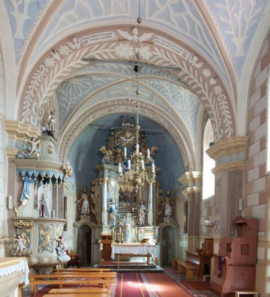 Zdjęcie nr 5: Kościół św. Walentego w Krempachach usytuowany jest na skraju wsi, na północ od drogi prowadzącej z Frydmanu do Łopusznej. Teren przykościelny jest otoczony kamiennym, murem nakrytym drewnianym daszkiem, jednospadowym, nachylonym na zewnątrz. W obrębie placu przykościelnego znajduje się cmentarz.
Kościół jest orientowany, murowany, otynkowany, jednonawowy z prezbiterium zamkniętym półkoliście. Wewnątrz sklepienia kolebkowe z lunetami. Prezbiterium oddzielone od nawy ścianą arkady tęczowej o półkolistym łuku, zdobionym napisem: „ERCETA SUPREMI IN NUMINIS / MAIOREM GLORIAM / DIVI VALENTINI EPI: ET MART. PAT/RONI CADUCORUM HONOREM / AN(N)O 1761 / RENO[VATUM] 1893”. Do prezbiterium przylega od północny zakrystia na planie prostokąta. Z kolei przy południowej ścianie nawy znajduje się kruchta z wejściem do świątyni ozdobiona wklęsło-wypukłym przyczółkiem. Na zachodniej ścianie nawy chór muzyczny wsparty jest na dwóch kolumnach z dostępem drewnianymi schodami od strony południowej nawy. Na balustradzie napis: „ABIICITE OPERA TENEBRARUM / ET INDUAMINI ARMA LUCIS”.
Wnętrze artykułowe zdwojonymi pilastrami podtrzymującymi gurty sklepienne. Otwory okienne umieszczone są w południowych i północnych ścianach nawy oraz prezbiterium – prostokątne, zamknięte półkoliście, wypełnione witrażami. Wejście do zakrystii od strony prezbiterium prowadzi poprzez kamienny portal z iluzjonistycznie malowanymi kanelowanymi kolumnami o korynckich kapitelach, wspierającymi profilowany gzyms, przyczółek trójkątny z wpisanym w polu Okiem Opatrzności.
Zewnętrzne elewacje bez dekoracji, skromne, otynkowane, oszkarpowane w nawie. Prezbiterium i nawa nakryte jednym, czterospadowym dachem z wieżą na sygnaturkę na zachodnim zakończeniu nawy. Do zachodniej fasady kościoła dostawiona jest kruchta na planie prostokąta, nakryta dwuspadowym daszkiem, od przodu ujęta przyczółkiem w kształcie wklęsło-wypukłym z uskokami. Z trzech stron kruchty prostokątne otwory wejściowe zamknięte półkoliście. Do kościoła prowadzi wejście przez kruchtę zachodnią oraz przez kruchtę od południa i jedno od strony północnej przez zakrystię. Zewnętrze obramienia okienne roślinną dekoracją sztukatorską. 