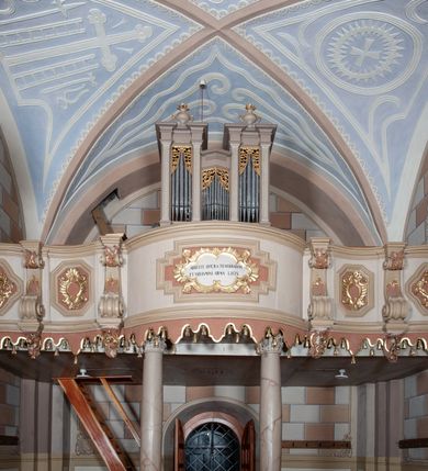 Zdjęcie nr 12: Kościół św. Walentego w Krempachach usytuowany jest na skraju wsi, na północ od drogi prowadzącej z Frydmanu do Łopusznej. Teren przykościelny jest otoczony kamiennym, murem nakrytym drewnianym daszkiem, jednospadowym, nachylonym na zewnątrz. W obrębie placu przykościelnego znajduje się cmentarz.
Kościół jest orientowany, murowany, otynkowany, jednonawowy z prezbiterium zamkniętym półkoliście. Wewnątrz sklepienia kolebkowe z lunetami. Prezbiterium oddzielone od nawy ścianą arkady tęczowej o półkolistym łuku, zdobionym napisem: „ERCETA SUPREMI IN NUMINIS / MAIOREM GLORIAM / DIVI VALENTINI EPI: ET MART. PAT/RONI CADUCORUM HONOREM / AN(N)O 1761 / RENO[VATUM] 1893”. Do prezbiterium przylega od północny zakrystia na planie prostokąta. Z kolei przy południowej ścianie nawy znajduje się kruchta z wejściem do świątyni ozdobiona wklęsło-wypukłym przyczółkiem. Na zachodniej ścianie nawy chór muzyczny wsparty jest na dwóch kolumnach z dostępem drewnianymi schodami od strony południowej nawy. Na balustradzie napis: „ABIICITE OPERA TENEBRARUM / ET INDUAMINI ARMA LUCIS”.
Wnętrze artykułowe zdwojonymi pilastrami podtrzymującymi gurty sklepienne. Otwory okienne umieszczone są w południowych i północnych ścianach nawy oraz prezbiterium – prostokątne, zamknięte półkoliście, wypełnione witrażami. Wejście do zakrystii od strony prezbiterium prowadzi poprzez kamienny portal z iluzjonistycznie malowanymi kanelowanymi kolumnami o korynckich kapitelach, wspierającymi profilowany gzyms, przyczółek trójkątny z wpisanym w polu Okiem Opatrzności.
Zewnętrzne elewacje bez dekoracji, skromne, otynkowane, oszkarpowane w nawie. Prezbiterium i nawa nakryte jednym, czterospadowym dachem z wieżą na sygnaturkę na zachodnim zakończeniu nawy. Do zachodniej fasady kościoła dostawiona jest kruchta na planie prostokąta, nakryta dwuspadowym daszkiem, od przodu ujęta przyczółkiem w kształcie wklęsło-wypukłym z uskokami. Z trzech stron kruchty prostokątne otwory wejściowe zamknięte półkoliście. Do kościoła prowadzi wejście przez kruchtę zachodnią oraz przez kruchtę od południa i jedno od strony północnej przez zakrystię. Zewnętrze obramienia okienne roślinną dekoracją sztukatorską. 