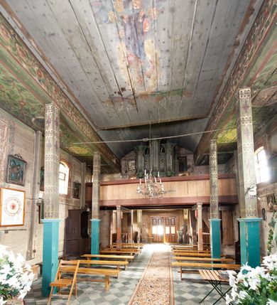 Zdjęcie nr 4: Prospekt organowy architektoniczny, pięcioosiowy, z wydzielonym cokołem. W osi środkowej i skrajnych ryzality półcylindryczne (środkowy wyższy i szerszy) z prześwitami, nadwieszone na profilowanych konsolach  i zwieńczone uproszczonym belkowaniem i profilowanymi gzymsami. W osiach wewnętrznych prostokątne prześwity zwieńczone prostokątnymi płycinami i odcinkami profilowanego gzymsu. Prześwity wypełnione piszczałkami; zwieńczone niepełnym belkowaniem, z profilowanym, silnie wysuniętym gzymsem. Wszystkie prześwity w górnej części wypełnione motywami liści akantu. Struktura polichromowana w kolorze niebieskozielonym, ornamenty na biało.