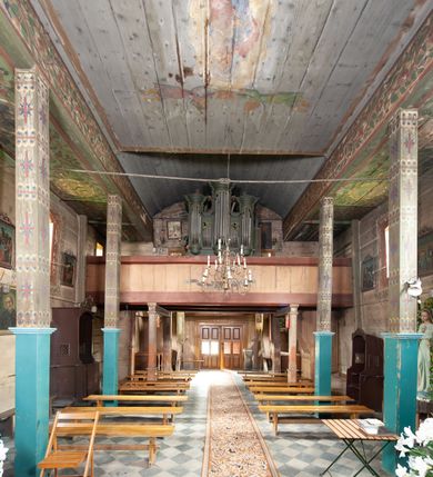 Zdjęcie nr 3: Prospekt organowy architektoniczny, pięcioosiowy, z wydzielonym cokołem. W osi środkowej i skrajnych ryzality półcylindryczne (środkowy wyższy i szerszy) z prześwitami, nadwieszone na profilowanych konsolach  i zwieńczone uproszczonym belkowaniem i profilowanymi gzymsami. W osiach wewnętrznych prostokątne prześwity zwieńczone prostokątnymi płycinami i odcinkami profilowanego gzymsu. Prześwity wypełnione piszczałkami; zwieńczone niepełnym belkowaniem, z profilowanym, silnie wysuniętym gzymsem. Wszystkie prześwity w górnej części wypełnione motywami liści akantu. Struktura polichromowana w kolorze niebieskozielonym, ornamenty na biało.