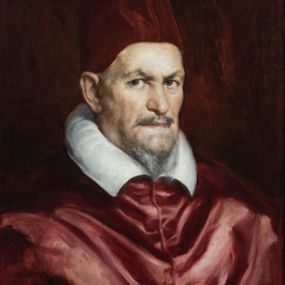 Zdjęcie nr 1: Obraz w kształcie stojącego prostokąta ujętego złoconą, profilowaną ramą. W centrum kompozycji, na jednolitym czerwono-brązowym tle ukazany papież Innocenty X przedstawiony w popiersiu, zwrócony w trzech czwartych w lewo. Postać ukazana jako starszy mężczyzna o przenikliwym spojrzeniu z krótką, siwiejącą brodą oraz niewielkim wąsem. Na głowie wysokie, czerwone nakrycie głowy – tzw. camauro. Ramiona okryte czerwonym mucetem wykonanym z połyskującej tkaniny, spod którego widoczny jest biały kołnierz. Na odwrociu obrazu kartka z drukowanym napisem„Ze zbiorów księdza Jana kniazia z Kozielska Puzyny księcia-biskupa krakowskiego numer 94” oraz odręcznie „Innocenty X / Don Diego Velázquez”.