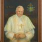 Zdjęcie nr 1: Obraz w kształcie stojącego prostokąta ujętego w drewnianą, profilowaną ramę. W centrum kompozycji, na jednolitym ciemnym tle ukazany frontalnie papież Jan Paweł II ujęty w popiersiu. Głowa pochylona nieznacznie do przodu i w lewo, ręce splecione na wysokości pasa, podtrzymujące różaniec. Wzrok postaci skierowany na wprost, usta w delikatnym uśmiechu. Papież ubrany w biały strój papieski z piuską na głowie i złotym pektorałem na piersi. W lewem górnym rogy obrazu napis „JAN PAWEŁ II”, po przeciwnej stronie herb papieski Jana Pawła II zwieńczony tiarą z podłożonymi pod tarczą dwoma kluczami. W prawym dolnym narożu kompozycji sygnatura „A(NTONI) GÓRNIK ’07”. Kolorystyka obrazu ciemna, stonowana.
