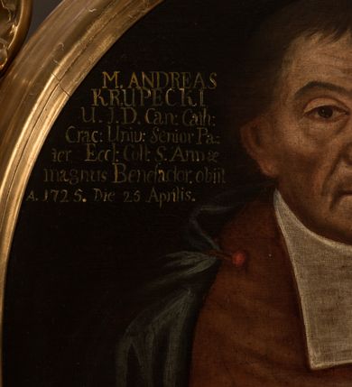 Zdjęcie nr 5: Obraz w kształcie owalu, w profilowanej ramie, zwieńczonej motywem rocaille&#039;ów. Na obrazie mężczyzna ubrany w białą komżę z koronkowymi mankietami, czerwony mucet i zielony płaszcz przewiązany czerwoną wstążką na prawym przedramieniu, z białymi befkami, z modlitewnikiem w ręku. W lewej górnej części obrazu napis „M(agister) ANDREAS / KRUPECKI / U(triusque) I(uris) D(octor) Can(onicus) Cath(edralis) / Crac(acoviensis) Uniu(erisitatis) Senior Pa/ter Eccl(lesiae) Coll(egiatae) S(antae) Annae / magnus Benefactor obiit / A(nno) 1725. Die 27 Aprilis.”. 