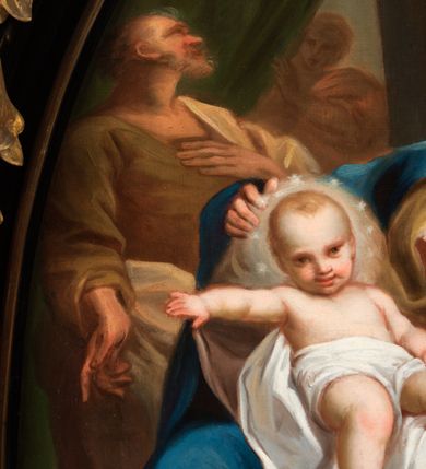 Zdjęcie nr 6: Kompozycja owalna w drewnianej, czarnej, profilowanej ramie. Na pierwszym planie ukazane trzy kobiety, z których jedna trzyma urodzoną właśnie Marię. Kobieta ukazana frontalnie, w pozycji siedzącej, ubrana w czerwoną suknię, niebieski płaszcz i brązową chustę na głowie, zwrócona w kierunku dwóch pozostałych piastunek. Na rękach trzyma dziecko, opatulone w białą pieluchę, z odsłoniętą klatką piersiową oraz nóżkami, z aureolą z gwiazd. Druga z kobiet ukazana z boku, z głową o czarnych włosach odwróconą od widza, z bandażem i dzbanem na wodę w rękach, ubrana w różową suknię i zieloną spódnicę. Trzecia z kobiet stojąca nieco z tyłu pochyla się nad nimi, ukazana z profilu, ubrana w zieloną suknię z włosami przewiązanymi chustą. W tle zarysowane szkicowo postacie: Joachima w brązowej sukni i białym płaszczu, z lewą ręką złożoną na piersi, prawą opuszczoną w dół, postać wyglądająca zza zielonej kotary oraz Anna leżąca na łożu, w zielonej sukni i białym welonie, przy której siedzi kobieta w brązowej sukni i białej chuście na głowie. Przed kobietami głęboka miedziana misa z wodą oraz fragment kołyski z poduszką. Pomieszczenie, w którym rozgrywa się scena, jest podzielone pośrodku kolumną, w lewej części widoczna półkolista arkada z kotarą, a po prawej pomieszczenie z łożem i podwieszoną pod sufitem, zieloną kotarą. Obok łoża Anny znajduje się stolik z okrągłym blatem, na którym leży miska z łyżką. 