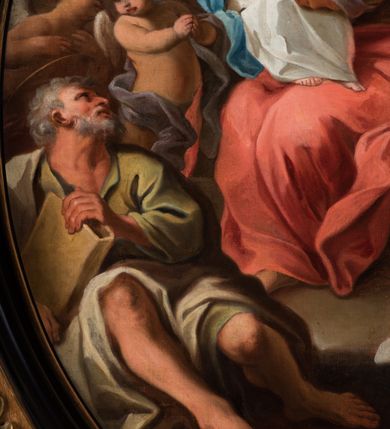 Zdjęcie nr 5: Kompozycja owalna w drewnianej, czarnej, profilowanej ramie, ukazuje siedzącą na krześle św. Annę z młodą Marią na jej kolanach i św. Joachima siedzącego u jej stóp z parą stojących za nim aniołów. Święta Anna ukazana jest w trzech czwartych, jej twarz jest wyrazista, oddana szkicowo, nos mały, usta uśmiechnięte, oczy zwrócone ku Marii. Ubrana jest w zielono-brązową suknię, czerwony płaszcz i brązową chustę zarzuconą na głowę. Maria przedstawiona jest frontalnie z rękami złożonymi na piersi, w białej sukni z brązową lamówka i niebieskim płaszczu okalającym biodra. Jej twarz jest okrągła, oczy uniesione ku górze, nos szeroki a usta wąskie; wokół głowy zarysowana jasna poświata z wieńcem z gwiazd. Święty Joachim został ukazany frontalnie, z głową odchyloną w kierunku św. Anny, ubrany w zieloną suknię i biały płaszcz; w ręku trzyma księgę w brązowej oprawie. Jego twarz ukazana wyraziście, z siwymi, skręconymi włosami i siwą, krótką, kręconą brodą. Za nim stoją dwa nagie putta, z tkaninami wokół bioder. W tle balustrada z lalkami, za którą widoczny krzew i lazurowe niebo oraz skłębione chmury, rozświetlone wokół hebrajskiej imienia Marii („מרים”).