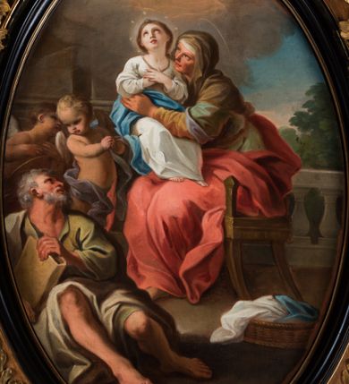 Zdjęcie nr 2: Kompozycja owalna w drewnianej, czarnej, profilowanej ramie, ukazuje siedzącą na krześle św. Annę z młodą Marią na jej kolanach i św. Joachima siedzącego u jej stóp z parą stojących za nim aniołów. Święta Anna ukazana jest w trzech czwartych, jej twarz jest wyrazista, oddana szkicowo, nos mały, usta uśmiechnięte, oczy zwrócone ku Marii. Ubrana jest w zielono-brązową suknię, czerwony płaszcz i brązową chustę zarzuconą na głowę. Maria przedstawiona jest frontalnie z rękami złożonymi na piersi, w białej sukni z brązową lamówka i niebieskim płaszczu okalającym biodra. Jej twarz jest okrągła, oczy uniesione ku górze, nos szeroki a usta wąskie; wokół głowy zarysowana jasna poświata z wieńcem z gwiazd. Święty Joachim został ukazany frontalnie, z głową odchyloną w kierunku św. Anny, ubrany w zieloną suknię i biały płaszcz; w ręku trzyma księgę w brązowej oprawie. Jego twarz ukazana wyraziście, z siwymi, skręconymi włosami i siwą, krótką, kręconą brodą. Za nim stoją dwa nagie putta, z tkaninami wokół bioder. W tle balustrada z lalkami, za którą widoczny krzew i lazurowe niebo oraz skłębione chmury, rozświetlone wokół hebrajskiej imienia Marii („מרים”).