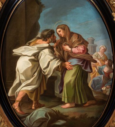 Zdjęcie nr 2: Obraz w owalnej, profilowanej, czarnej ramie, ukazuje scenę spotkania Joachima i Anny. Mężczyzna przedstawiony w trzech czwartych, od tyłu, z prawą nogą zgiętą w kolanie i z rękami rozłożonymi w geście powitania. Jego głowa jest ukazana z profilu, z wyrazistym nosem, brązowymi kręconymi włosami i krótką, falistą brodą. Joachim jest ubrany w długą, brązową suknię przylegającą do ciała i biały płaszcz okrywający ramiona i ręce oraz brązowe sandały. Anna zwrócona do Joachima, ukazana w trzech czwartych z lewą ręką na piersi, z drugą niewidoczną. Jej twarz jest dojrzała, zarysowano szkicowo, nos krótki, oczy w płytkich oczodołach. Anna jest ubrana w różową koszulę, zieloną suknię, niebieski płaszcz i brązową, długą chustę zarzuconą na głowę. Nad głowami obojga małżonków aureole. W tle dwie kobiety. Jedna klęczy, jest ubrana w białą koszulę, czerwoną suknię i niebieski płaszcz i wskazuje prawą ręką na postacie na pierwszym planie, a lewą opiera na wiklinowym koszyku z bielizną. Druga kobieta jest ukazana w pozycji stojącej, frontalnie, ubrana w jasnozieloną suknię i pomarańczowy płaszcz z turbanem na głowie. Za nimi widoczne budowle antyczne, pierwsza w formie okrągłej świątyni (tempietta) ujęta kolumnami, druga w kształcie antycznej świątyni z portykiem kolumnowym w fasadzie; obie zarysowane szkicowo. Na pierwszym planie tobołek podróżny z kijem. W lewej części kompozycji fragment skały. Niebo w kolorach intensywnego lazuru, przełamane szarościami. 