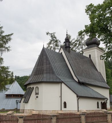 Zdjęcie nr 14: Kościół św. Kwiryna w Łapszach Niżnych usytuowany jest w centrum wsi w pobliżu rzeki Łapszanki. Teren przykościelny jest otoczony wysokim kamiennym, murem nakrytym cementowym daszkiem, jednospadowym, nachylonym na zewnątrz. W części wschodniej muru zlokalizowana jest brama, dostępna schodami, flankowana dwoma filarami, zwieńczonymi czterospadowym płaskim daszkiem i kulami. Analogiczne wejścia od strony zachodniej, północnej i południowej. W obrębie placu przykościelnego znajdują się resztki cmentarza w postaci nagrobków.

Kościół jest orientowany, murowany, otynkowany, jednonawowy z czworoboczną wieżą w fasadzie z prezbiterium zamkniętym trójbocznie. Prezbiterium nakryte sklepieniem krzyżowo-żebrowym, oddzielone od nawy ścianą arkady tęczowej o ostrołukowym zakończeniu. Nawa jest szersza, nakryta stropem. Do prezbiterium przylega od północny niewielka zakrystia na planie prostokąta, a także przylegająca do niej i do ściany nawy druga nowsza zakrystia. Z kolei przy południowej ścianie nawy znajduje się kruchta, zwana babińcem z wejściem do świątyni. Portal prowadzący z kruchty do kościoła ostrołukowy, kamienny, skromnie profilowany – dwa wałki i dwa żłobki. Portal zamknięty drzwiami ze starymi ćwiekowymi okuciami, malowany z wypisaną datą 1652. Na drzwiach napis: „Laudetur Santissimum Sacramentum 1652”. Z kolei na północnej ścianie prezbiterium portal malowany, iluzjonistyczny z wejściem do zakrystii. U góry napis: „PIETAS ET LITTERAE”. Na zachodniej ścianie nawy chór muzyczny wsparty na dwóch filarach z dostępem kręconymi, drewnianymi schodami od północy. 

Wnętrze oświetlają umieszczone w południowych ścianach nawy prostokątne, zamknięte półkoliście cztery okna oraz jedno od strony południowej w prezbiterium; w cztery podobne, małe okna umieszczone po jednym z każdej strony w najwyższej kondygnacji. Do kościoła prowadzi główne wejście od strony zachodniej oraz jedno przez kruchtę od południa i jedno od strony północnej przez zakrystię.

W zewnętrznej elewacji kościoła widoczny jest niewysoki, kamienny cokół, powyżej kościół otynkowany. Prezbiterium, niższe od nawy. Nawa nakryta dachem dwuspadowym z wieżą na sygnaturkę na wschodnim zakończeniu nawy. Do zachodniej fasady kościoła dostawiona jest wysoka założona na planie kwadratu wieża-dzwonnica. W dolnej kondygnacji na osi kościoła prostokątne wejście do kruchty, nakryte daszkiem. Hełm wieży baniasty z latarnią. Na zewnątrz przy apsydzie prezbiterium dwie skarpy złączone daszkiem tworzą wnękę, w której umieszczony jest stół ołtarzowy i grupa Ukrzyżowania tzw. kalwaryjka. Na południowej ścianie nawy znajdował się zegar słoneczny, obecnie pozostała tylko wskazówka po zamalowaniu podczas remontu ścian zewnętrznych.

