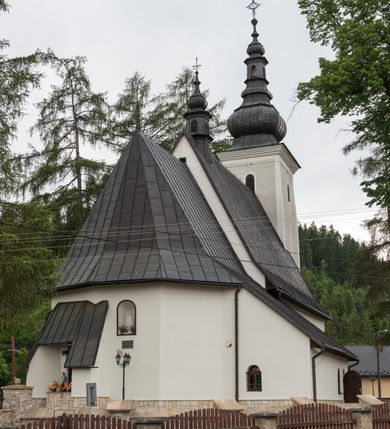 Zdjęcie nr 15: Kościół św. Kwiryna w Łapszach Niżnych usytuowany jest w centrum wsi w pobliżu rzeki Łapszanki. Teren przykościelny jest otoczony wysokim kamiennym, murem nakrytym cementowym daszkiem, jednospadowym, nachylonym na zewnątrz. W części wschodniej muru zlokalizowana jest brama, dostępna schodami, flankowana dwoma filarami, zwieńczonymi czterospadowym płaskim daszkiem i kulami. Analogiczne wejścia od strony zachodniej, północnej i południowej. W obrębie placu przykościelnego znajdują się resztki cmentarza w postaci nagrobków.

Kościół jest orientowany, murowany, otynkowany, jednonawowy z czworoboczną wieżą w fasadzie z prezbiterium zamkniętym trójbocznie. Prezbiterium nakryte sklepieniem krzyżowo-żebrowym, oddzielone od nawy ścianą arkady tęczowej o ostrołukowym zakończeniu. Nawa jest szersza, nakryta stropem. Do prezbiterium przylega od północny niewielka zakrystia na planie prostokąta, a także przylegająca do niej i do ściany nawy druga nowsza zakrystia. Z kolei przy południowej ścianie nawy znajduje się kruchta, zwana babińcem z wejściem do świątyni. Portal prowadzący z kruchty do kościoła ostrołukowy, kamienny, skromnie profilowany – dwa wałki i dwa żłobki. Portal zamknięty drzwiami ze starymi ćwiekowymi okuciami, malowany z wypisaną datą 1652. Na drzwiach napis: „Laudetur Santissimum Sacramentum 1652”. Z kolei na północnej ścianie prezbiterium portal malowany, iluzjonistyczny z wejściem do zakrystii. U góry napis: „PIETAS ET LITTERAE”. Na zachodniej ścianie nawy chór muzyczny wsparty na dwóch filarach z dostępem kręconymi, drewnianymi schodami od północy. 

Wnętrze oświetlają umieszczone w południowych ścianach nawy prostokątne, zamknięte półkoliście cztery okna oraz jedno od strony południowej w prezbiterium; w cztery podobne, małe okna umieszczone po jednym z każdej strony w najwyższej kondygnacji. Do kościoła prowadzi główne wejście od strony zachodniej oraz jedno przez kruchtę od południa i jedno od strony północnej przez zakrystię.

W zewnętrznej elewacji kościoła widoczny jest niewysoki, kamienny cokół, powyżej kościół otynkowany. Prezbiterium, niższe od nawy. Nawa nakryta dachem dwuspadowym z wieżą na sygnaturkę na wschodnim zakończeniu nawy. Do zachodniej fasady kościoła dostawiona jest wysoka założona na planie kwadratu wieża-dzwonnica. W dolnej kondygnacji na osi kościoła prostokątne wejście do kruchty, nakryte daszkiem. Hełm wieży baniasty z latarnią. Na zewnątrz przy apsydzie prezbiterium dwie skarpy złączone daszkiem tworzą wnękę, w której umieszczony jest stół ołtarzowy i grupa Ukrzyżowania tzw. kalwaryjka. Na południowej ścianie nawy znajdował się zegar słoneczny, obecnie pozostała tylko wskazówka po zamalowaniu podczas remontu ścian zewnętrznych.

