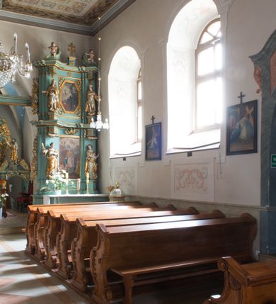 Zdjęcie nr 7: Kościół św. Kwiryna w Łapszach Niżnych usytuowany jest w centrum wsi w pobliżu rzeki Łapszanki. Teren przykościelny jest otoczony wysokim kamiennym, murem nakrytym cementowym daszkiem, jednospadowym, nachylonym na zewnątrz. W części wschodniej muru zlokalizowana jest brama, dostępna schodami, flankowana dwoma filarami, zwieńczonymi czterospadowym płaskim daszkiem i kulami. Analogiczne wejścia od strony zachodniej, północnej i południowej. W obrębie placu przykościelnego znajdują się resztki cmentarza w postaci nagrobków.

Kościół jest orientowany, murowany, otynkowany, jednonawowy z czworoboczną wieżą w fasadzie z prezbiterium zamkniętym trójbocznie. Prezbiterium nakryte sklepieniem krzyżowo-żebrowym, oddzielone od nawy ścianą arkady tęczowej o ostrołukowym zakończeniu. Nawa jest szersza, nakryta stropem. Do prezbiterium przylega od północny niewielka zakrystia na planie prostokąta, a także przylegająca do niej i do ściany nawy druga nowsza zakrystia. Z kolei przy południowej ścianie nawy znajduje się kruchta, zwana babińcem z wejściem do świątyni. Portal prowadzący z kruchty do kościoła ostrołukowy, kamienny, skromnie profilowany – dwa wałki i dwa żłobki. Portal zamknięty drzwiami ze starymi ćwiekowymi okuciami, malowany z wypisaną datą 1652. Na drzwiach napis: „Laudetur Santissimum Sacramentum 1652”. Z kolei na północnej ścianie prezbiterium portal malowany, iluzjonistyczny z wejściem do zakrystii. U góry napis: „PIETAS ET LITTERAE”. Na zachodniej ścianie nawy chór muzyczny wsparty na dwóch filarach z dostępem kręconymi, drewnianymi schodami od północy. 

Wnętrze oświetlają umieszczone w południowych ścianach nawy prostokątne, zamknięte półkoliście cztery okna oraz jedno od strony południowej w prezbiterium; w cztery podobne, małe okna umieszczone po jednym z każdej strony w najwyższej kondygnacji. Do kościoła prowadzi główne wejście od strony zachodniej oraz jedno przez kruchtę od południa i jedno od strony północnej przez zakrystię.

W zewnętrznej elewacji kościoła widoczny jest niewysoki, kamienny cokół, powyżej kościół otynkowany. Prezbiterium, niższe od nawy. Nawa nakryta dachem dwuspadowym z wieżą na sygnaturkę na wschodnim zakończeniu nawy. Do zachodniej fasady kościoła dostawiona jest wysoka założona na planie kwadratu wieża-dzwonnica. W dolnej kondygnacji na osi kościoła prostokątne wejście do kruchty, nakryte daszkiem. Hełm wieży baniasty z latarnią. Na zewnątrz przy apsydzie prezbiterium dwie skarpy złączone daszkiem tworzą wnękę, w której umieszczony jest stół ołtarzowy i grupa Ukrzyżowania tzw. kalwaryjka. Na południowej ścianie nawy znajdował się zegar słoneczny, obecnie pozostała tylko wskazówka po zamalowaniu podczas remontu ścian zewnętrznych.

