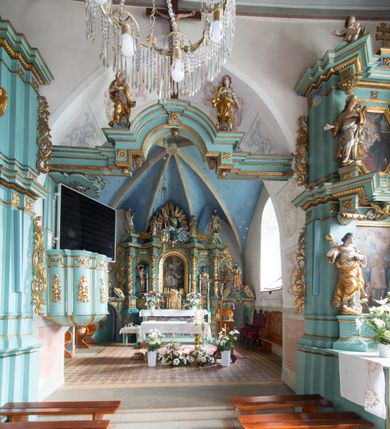 Zdjęcie nr 4: Kościół św. Kwiryna w Łapszach Niżnych usytuowany jest w centrum wsi w pobliżu rzeki Łapszanki. Teren przykościelny jest otoczony wysokim kamiennym, murem nakrytym cementowym daszkiem, jednospadowym, nachylonym na zewnątrz. W części wschodniej muru zlokalizowana jest brama, dostępna schodami, flankowana dwoma filarami, zwieńczonymi czterospadowym płaskim daszkiem i kulami. Analogiczne wejścia od strony zachodniej, północnej i południowej. W obrębie placu przykościelnego znajdują się resztki cmentarza w postaci nagrobków.

Kościół jest orientowany, murowany, otynkowany, jednonawowy z czworoboczną wieżą w fasadzie z prezbiterium zamkniętym trójbocznie. Prezbiterium nakryte sklepieniem krzyżowo-żebrowym, oddzielone od nawy ścianą arkady tęczowej o ostrołukowym zakończeniu. Nawa jest szersza, nakryta stropem. Do prezbiterium przylega od północny niewielka zakrystia na planie prostokąta, a także przylegająca do niej i do ściany nawy druga nowsza zakrystia. Z kolei przy południowej ścianie nawy znajduje się kruchta, zwana babińcem z wejściem do świątyni. Portal prowadzący z kruchty do kościoła ostrołukowy, kamienny, skromnie profilowany – dwa wałki i dwa żłobki. Portal zamknięty drzwiami ze starymi ćwiekowymi okuciami, malowany z wypisaną datą 1652. Na drzwiach napis: „Laudetur Santissimum Sacramentum 1652”. Z kolei na północnej ścianie prezbiterium portal malowany, iluzjonistyczny z wejściem do zakrystii. U góry napis: „PIETAS ET LITTERAE”. Na zachodniej ścianie nawy chór muzyczny wsparty na dwóch filarach z dostępem kręconymi, drewnianymi schodami od północy. 

Wnętrze oświetlają umieszczone w południowych ścianach nawy prostokątne, zamknięte półkoliście cztery okna oraz jedno od strony południowej w prezbiterium; w cztery podobne, małe okna umieszczone po jednym z każdej strony w najwyższej kondygnacji. Do kościoła prowadzi główne wejście od strony zachodniej oraz jedno przez kruchtę od południa i jedno od strony północnej przez zakrystię.

W zewnętrznej elewacji kościoła widoczny jest niewysoki, kamienny cokół, powyżej kościół otynkowany. Prezbiterium, niższe od nawy. Nawa nakryta dachem dwuspadowym z wieżą na sygnaturkę na wschodnim zakończeniu nawy. Do zachodniej fasady kościoła dostawiona jest wysoka założona na planie kwadratu wieża-dzwonnica. W dolnej kondygnacji na osi kościoła prostokątne wejście do kruchty, nakryte daszkiem. Hełm wieży baniasty z latarnią. Na zewnątrz przy apsydzie prezbiterium dwie skarpy złączone daszkiem tworzą wnękę, w której umieszczony jest stół ołtarzowy i grupa Ukrzyżowania tzw. kalwaryjka. Na południowej ścianie nawy znajdował się zegar słoneczny, obecnie pozostała tylko wskazówka po zamalowaniu podczas remontu ścian zewnętrznych.

