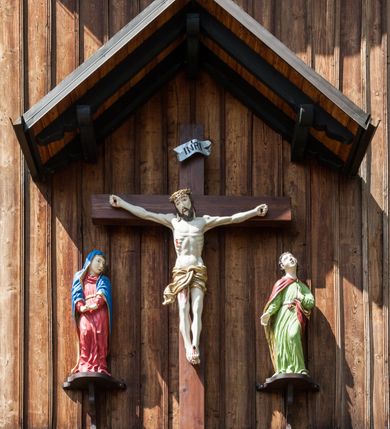 Zdjęcie nr 9: Kościół drewniany, o konstrukcji ramowej, na kamiennej podmurówce, elewacje jednolite, szalowane z listwowaniem o układzie pionowym z gzymsami pseudoarkadkowymi. Wieża zachodnia o konstrukcji słupowej, z szalunkiem o układzie poziomym z fryzem arkadkowym w górnej partii. Więźba dachowa drewniana, krokwiowa. Budynek na betonowym podmurowaniu przesłoniętym daszkiem gontowym. Kościół orientowany, trójnawowy, na rzucie wydłużonego krzyża, z płytkim transeptem, prezbiterium zakończone trójbocznie, z zakrystią przylegającą od południa, na skrzyżowaniu naw kopuła. Od zachodu wieża czterokondygnacyjna, na planie kwadratu przechodzącego w kwadrat o coraz bardziej ściętych narożach, ujęta dwiema kruchtami na rzucie kwadratu. Wnętrze o układzie bazylikowym, nawy podzielone smukłymi, żeliwnymi kolumienkami. Pomiędzy nawą a prezbiterium otwór tęczowy w formie kwadratu o ściętych narożach. Parapet chóru muzycznego w zachodniej części kościoła podparty na czterech kolumienkach. Nawa główna nakryta stropem z widocznymi elementami konstrukcji więźby, nawy boczne przekryte pułapami deskowymi. Posadzka z płyt kamiennych. Elewacja frontowa w formie wieży z dwoma kruchtami. Na każdej z trzech osi wejście z dwuskrzydłowymi drzwiami klepkowymi o układzie rombowym, z oknami w partii szczytu, nakryte daszkami okapowymi. Nad wejściem głównym żeliwna tabliczka z napisem „E(RZ)H(ERZOG) / ALBRECHT / 1888”. Na każdej kondygnacji wieży okna w formie stojącego prostokąta zwieńczone daszkami pulpitowymi, na pierwszej jedno, na drugiej trzy, na trzeciej cztery, na czwartej osiem. W elewacji północnej i południowej cztery podwójne otwory okienne w formie stojącego prostokąta o ściętych górnych narożach w partii naw bocznych oraz pięć okienek w formie leżącego prostokąta w partii nawy głównej. W elewacji południowej wejście z dwuskrzydłowymi drzwiami klepkowymi o układzie rombowym. Na osi skrzydeł transeptu po jednym otworze okiennym w formie stojącego prostokąta o ściętych górnych narożach. Na ścianie wschodniej prezbiterium Ogrójec w formie grupy Ukrzyżowania nakrytej daszkiem pulpitowym, flankowany dwoma otworami okiennymi w kształcie stojącego prostokąta o ściętych górnych narożach. Nawa główna nakryta dachem dwuspadowym. W połowie długości dachu oraz na skrzyżowaniu naw wznoszą się ponad kalenicą wieżyczki na sygnaturkę, na ośmiobocznym obitym blachą trzonie, z latarniami zwieńczonymi cebulastymi hełmami. Nad nawami bocznymi dachy pulpitowe, ramiona transeptu nakrywają dachy naczółkowe. Wieża zwieńczona dachem wieżowym, ośmiobocznym, z iglicą zakończoną krzyżem. 


