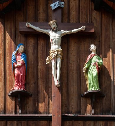 Zdjęcie nr 23: Kościół drewniany, o konstrukcji ramowej, na kamiennej podmurówce, elewacje jednolite, szalowane z listwowaniem o układzie pionowym z gzymsami pseudoarkadkowymi. Wieża zachodnia o konstrukcji słupowej, z szalunkiem o układzie poziomym z fryzem arkadkowym w górnej partii. Więźba dachowa drewniana, krokwiowa. Budynek na betonowym podmurowaniu przesłoniętym daszkiem gontowym. Kościół orientowany, trójnawowy, na rzucie wydłużonego krzyża, z płytkim transeptem, prezbiterium zakończone trójbocznie, z zakrystią przylegającą od południa, na skrzyżowaniu naw kopuła. Od zachodu wieża czterokondygnacyjna, na planie kwadratu przechodzącego w kwadrat o coraz bardziej ściętych narożach, ujęta dwiema kruchtami na rzucie kwadratu. Wnętrze o układzie bazylikowym, nawy podzielone smukłymi, żeliwnymi kolumienkami. Pomiędzy nawą a prezbiterium otwór tęczowy w formie kwadratu o ściętych narożach. Parapet chóru muzycznego w zachodniej części kościoła podparty na czterech kolumienkach. Nawa główna nakryta stropem z widocznymi elementami konstrukcji więźby, nawy boczne przekryte pułapami deskowymi. Posadzka z płyt kamiennych. Elewacja frontowa w formie wieży z dwoma kruchtami. Na każdej z trzech osi wejście z dwuskrzydłowymi drzwiami klepkowymi o układzie rombowym, z oknami w partii szczytu, nakryte daszkami okapowymi. Nad wejściem głównym żeliwna tabliczka z napisem „E(RZ)H(ERZOG) / ALBRECHT / 1888”. Na każdej kondygnacji wieży okna w formie stojącego prostokąta zwieńczone daszkami pulpitowymi, na pierwszej jedno, na drugiej trzy, na trzeciej cztery, na czwartej osiem. W elewacji północnej i południowej cztery podwójne otwory okienne w formie stojącego prostokąta o ściętych górnych narożach w partii naw bocznych oraz pięć okienek w formie leżącego prostokąta w partii nawy głównej. W elewacji południowej wejście z dwuskrzydłowymi drzwiami klepkowymi o układzie rombowym. Na osi skrzydeł transeptu po jednym otworze okiennym w formie stojącego prostokąta o ściętych górnych narożach. Na ścianie wschodniej prezbiterium Ogrójec w formie grupy Ukrzyżowania nakrytej daszkiem pulpitowym, flankowany dwoma otworami okiennymi w kształcie stojącego prostokąta o ściętych górnych narożach. Nawa główna nakryta dachem dwuspadowym. W połowie długości dachu oraz na skrzyżowaniu naw wznoszą się ponad kalenicą wieżyczki na sygnaturkę, na ośmiobocznym obitym blachą trzonie, z latarniami zwieńczonymi cebulastymi hełmami. Nad nawami bocznymi dachy pulpitowe, ramiona transeptu nakrywają dachy naczółkowe. Wieża zwieńczona dachem wieżowym, ośmiobocznym, z iglicą zakończoną krzyżem. 


