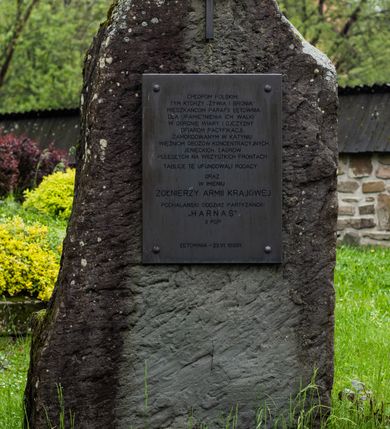 Zdjęcie nr 61: Kościół drewniany o konstrukcji zrębowej, elewacje jednolite, szalowane z listwowaniem, wzmocnione lisicami, wieża o konstrukcji słupowej. Więźba dachowa drewniana, krokwiowa. Budynek na kamiennym podmurowaniu przesłoniętym daszkiem gontowym. Kościół orientowany, jednonawowy z dwiema kaplicami o charakterze transeptu zamkniętymi wielobocznie, na planie krzyża łacińskiego, o węższym prezbiterium zamkniętym trójbocznie. Do wschodniej ściany prezbiterium przylega ogrójec w formie kapliczki, od północy zakrystia na planie prostokąta. Na skrzyżowaniu nawy z południowym ramieniem transeptu kruchta na planie prostokąta. Od zachodu do nawy przylega wieża na planie kwadratu, otoczona sobotami. Prezbiterium i nawa nakryte pozornym sklepieniem tej samej szerokości, obwiedzionym dużym, profilowanym gzymsem podtrzymywanym w nawie przez dwie pary filarów o kanelowanych trzonach, na cokołach. Sklepieniu nawy głównej towarzyszą płaskie i niższe stropy z fasetami w przestrzeniach bocznych. Ściany boczne nawy zwieńczone profilowanym gzymsem. Pomiędzy nawą a prezbiterium otwór tęczowy w formie odcinkowej arkady podtrzymywanej przez filary o kanelowanych trzonach z belką o falistym zarysie. Kaplice boczne otwarte do nawy odcinkowymi arkadami podtrzymywanymi przez filary o kanelowanych trzonach, na cokołach. Parapet chóru muzycznego w zachodniej części nawy, o wybrzuszonej środkowej części, podparty na dwóch filarach o kanelowanych trzonach, na cokołach. Posadzka z płyt ceramicznych. Elewacja frontowa w postaci wieży otoczonej sobotami. Na osi frontowej ściany sobót płytka kruchta zwieńczona gzymsem z przyczółkiem wypełnionym motywem „słoneczka”, przykryta dwuspadowym dachem. Drzwi dwuskrzydłowe, drewniane z okuciami. Korpus wieży podzielony poziomo daszkiem okapowym w dwóch trzecich wysokości, na froncie okno. W dolnej części małe otwory dzwonne z trzech stron, w górnej części duże otwory dzwonne z czterech stron. Wieża zwieńczona hełmem baniastym z latarnią. Ściany sobót szalowane z poziomym listwowaniem, przekryte mansardowym dachem gontowym, na północnej i południowej ścianie dwie pary okien w formie leżącego prostokąta zamkniętego łukiem odcinkowym. W elewacji południowej cztery otwory okienne w formie stojącego prostokąta zamkniętego łukiem odcinkowym, w partii prezbiterium z witrażami. Na elewacji wschodniej ogrójec w formie nadwieszonej kapliczki nakrytej dwuspadowym daszkiem z grupą Ukrzyżowania. W elewacji północnej dwa otwory okienne w formie stojącego prostokąta zamkniętego łukiem odcinkowym. W zakrystii małe kwadratowe okienko. W obu ramionach transeptu analogiczne jak w elewacjach otwory okienne na wschodniej i zachodniej ścianie. Kościół nakryty dachami gontowymi, wyższym nad nawą, niższym nad prezbiterium, dwuspadowym nad nawą oraz wielospadowym nad prezbiterium i ramionami transeptu; nad zakrystią i kruchtą boczną dachy dwuspadowe. W połowie długości dachu, nad nawą, od strony prezbiterium wznosi się ponad kalenicą wieżyczka na sygnaturkę, obita blachą, na ośmiobocznym trzonie, z latarnią zwieńczoną niewielkim baniastym hełmem z latarnią.
