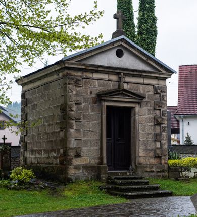 Zdjęcie nr 60: Kościół drewniany o konstrukcji zrębowej, elewacje jednolite, szalowane z listwowaniem, wzmocnione lisicami, wieża o konstrukcji słupowej. Więźba dachowa drewniana, krokwiowa. Budynek na kamiennym podmurowaniu przesłoniętym daszkiem gontowym. Kościół orientowany, jednonawowy z dwiema kaplicami o charakterze transeptu zamkniętymi wielobocznie, na planie krzyża łacińskiego, o węższym prezbiterium zamkniętym trójbocznie. Do wschodniej ściany prezbiterium przylega ogrójec w formie kapliczki, od północy zakrystia na planie prostokąta. Na skrzyżowaniu nawy z południowym ramieniem transeptu kruchta na planie prostokąta. Od zachodu do nawy przylega wieża na planie kwadratu, otoczona sobotami. Prezbiterium i nawa nakryte pozornym sklepieniem tej samej szerokości, obwiedzionym dużym, profilowanym gzymsem podtrzymywanym w nawie przez dwie pary filarów o kanelowanych trzonach, na cokołach. Sklepieniu nawy głównej towarzyszą płaskie i niższe stropy z fasetami w przestrzeniach bocznych. Ściany boczne nawy zwieńczone profilowanym gzymsem. Pomiędzy nawą a prezbiterium otwór tęczowy w formie odcinkowej arkady podtrzymywanej przez filary o kanelowanych trzonach z belką o falistym zarysie. Kaplice boczne otwarte do nawy odcinkowymi arkadami podtrzymywanymi przez filary o kanelowanych trzonach, na cokołach. Parapet chóru muzycznego w zachodniej części nawy, o wybrzuszonej środkowej części, podparty na dwóch filarach o kanelowanych trzonach, na cokołach. Posadzka z płyt ceramicznych. Elewacja frontowa w postaci wieży otoczonej sobotami. Na osi frontowej ściany sobót płytka kruchta zwieńczona gzymsem z przyczółkiem wypełnionym motywem „słoneczka”, przykryta dwuspadowym dachem. Drzwi dwuskrzydłowe, drewniane z okuciami. Korpus wieży podzielony poziomo daszkiem okapowym w dwóch trzecich wysokości, na froncie okno. W dolnej części małe otwory dzwonne z trzech stron, w górnej części duże otwory dzwonne z czterech stron. Wieża zwieńczona hełmem baniastym z latarnią. Ściany sobót szalowane z poziomym listwowaniem, przekryte mansardowym dachem gontowym, na północnej i południowej ścianie dwie pary okien w formie leżącego prostokąta zamkniętego łukiem odcinkowym. W elewacji południowej cztery otwory okienne w formie stojącego prostokąta zamkniętego łukiem odcinkowym, w partii prezbiterium z witrażami. Na elewacji wschodniej ogrójec w formie nadwieszonej kapliczki nakrytej dwuspadowym daszkiem z grupą Ukrzyżowania. W elewacji północnej dwa otwory okienne w formie stojącego prostokąta zamkniętego łukiem odcinkowym. W zakrystii małe kwadratowe okienko. W obu ramionach transeptu analogiczne jak w elewacjach otwory okienne na wschodniej i zachodniej ścianie. Kościół nakryty dachami gontowymi, wyższym nad nawą, niższym nad prezbiterium, dwuspadowym nad nawą oraz wielospadowym nad prezbiterium i ramionami transeptu; nad zakrystią i kruchtą boczną dachy dwuspadowe. W połowie długości dachu, nad nawą, od strony prezbiterium wznosi się ponad kalenicą wieżyczka na sygnaturkę, obita blachą, na ośmiobocznym trzonie, z latarnią zwieńczoną niewielkim baniastym hełmem z latarnią.
