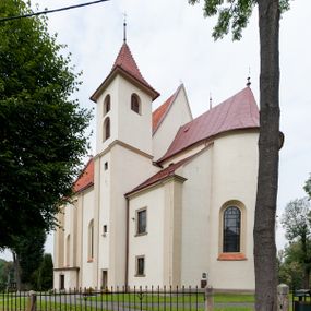 Zdjęcie nr 1: Kościół jest jednonawowy, trójprzęsłowy, z płytkimi kaplicami tworzącymi pseudotransept i jednoprzęsłowym prezbiterium zakończonym apsydą. Do prezbiterium przylegają dwa aneksy mieszące w przyziemiu zakrystię i skarbczyk, a na piętrze empory otwarte na prezbiterium. Do nawy od południa dostawiona jest kruchta. W naroża między kaplicami a nawą wstawiono dwie wieże-dzwonnice z klatkami schodowymi prowadzącymi na empory. Nawa jest rozczłonkowana płaskimi, szerokimi pilastrami toskańskimi, a nakryta sklepieniem kolebkowym z lunetami; prezbiterium przykryte sklepieniem kolebkowym z żebrami spływającymi na wsporniki, apsyda sklepieniem parasolowatym.  Prezbiterium ujęte dwiema głębokimi, półkoliście zamkniętymi wnękami, nad którymi parapety empor z ślepymi arkadkami z balasów jenolalkowych i łuków półkolistych. Wnętrze oświetlają wysokie i szerokie okna zamknięte półkoliście. W aneksach przy prezbiterium i w emporach znajdują się okna prostokątne. Fasada dwustrefowa, trójosiowa, ale osie i strefy wyznaczone jedynie przez okna, drzwi i nisze, zamknięta trójkątnie.    
Portal prostokątnych drzwi utworzony z pary żłobkowanych, toskańskich pilastrów, podtrzymujących belkowanie z trójkątnym przyczółkiem. Fryz belkowania ozdobiony tryglifami z łezkami i metopami w kształcie rozet i talerzy, a przyczółek kostkowaniem. Nad portalem okno w głębokim rozglifieniu, w kształcie prostokąta zamkniętego półkoliście. Po bokach portalu i okna głębokie nisze ujęte od dołu i góry odcinkami gzymsu. Zewnętrzne elewacje ujęte częściowo szkarpami, częściowo lizenami. W wieżach wejścia do kościoła i na klatki schodowe oraz niewielkie okienka w klatce schodowej i prześwity zamknięte półkoliście w dzwonnicach. Dachy dwuspadowe, na wieżach czterospadowe, nad nawą, wieżami i aneksami przy prezbiterium kryte dachówką, nad prezbiterium blachą. Na dachu wieżyczka na sygnaturkę. 
