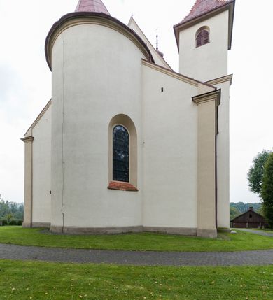 Zdjęcie nr 6: Kościół jest jednonawowy, trójprzęsłowy, z płytkimi kaplicami tworzącymi pseudotransept i jednoprzęsłowym prezbiterium zakończonym apsydą. Do prezbiterium przylegają dwa aneksy mieszące w przyziemiu zakrystię i skarbczyk, a na piętrze empory otwarte na prezbiterium. Do nawy od południa dostawiona jest kruchta. W naroża między kaplicami a nawą wstawiono dwie wieże-dzwonnice z klatkami schodowymi prowadzącymi na empory. Nawa jest rozczłonkowana płaskimi, szerokimi pilastrami toskańskimi, a nakryta sklepieniem kolebkowym z lunetami; prezbiterium przykryte sklepieniem kolebkowym z żebrami spływającymi na wsporniki, apsyda sklepieniem parasolowatym.  Prezbiterium ujęte dwiema głębokimi, półkoliście zamkniętymi wnękami, nad którymi parapety empor z ślepymi arkadkami z balasów jenolalkowych i łuków półkolistych. Wnętrze oświetlają wysokie i szerokie okna zamknięte półkoliście. W aneksach przy prezbiterium i w emporach znajdują się okna prostokątne. Fasada dwustrefowa, trójosiowa, ale osie i strefy wyznaczone jedynie przez okna, drzwi i nisze, zamknięta trójkątnie.    
Portal prostokątnych drzwi utworzony z pary żłobkowanych, toskańskich pilastrów, podtrzymujących belkowanie z trójkątnym przyczółkiem. Fryz belkowania ozdobiony tryglifami z łezkami i metopami w kształcie rozet i talerzy, a przyczółek kostkowaniem. Nad portalem okno w głębokim rozglifieniu, w kształcie prostokąta zamkniętego półkoliście. Po bokach portalu i okna głębokie nisze ujęte od dołu i góry odcinkami gzymsu. Zewnętrzne elewacje ujęte częściowo szkarpami, częściowo lizenami. W wieżach wejścia do kościoła i na klatki schodowe oraz niewielkie okienka w klatce schodowej i prześwity zamknięte półkoliście w dzwonnicach. Dachy dwuspadowe, na wieżach czterospadowe, nad nawą, wieżami i aneksami przy prezbiterium kryte dachówką, nad prezbiterium blachą. Na dachu wieżyczka na sygnaturkę. 
